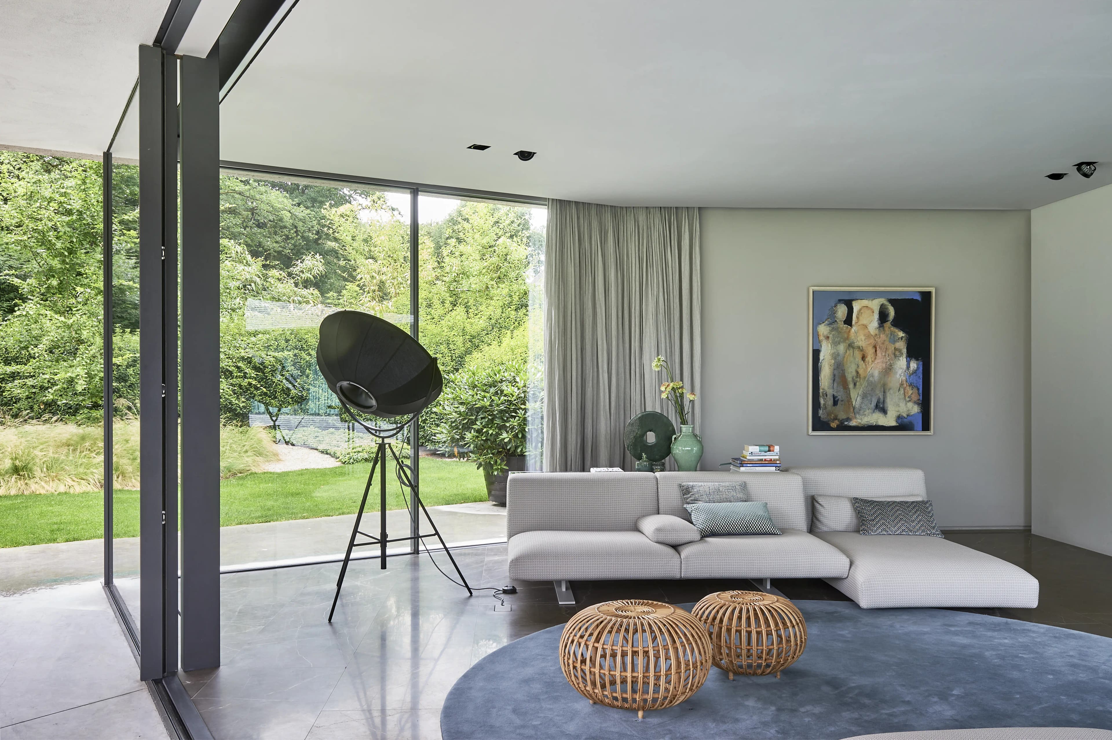 Woonruimte met industriële staande lamp en grijze modulaire bank