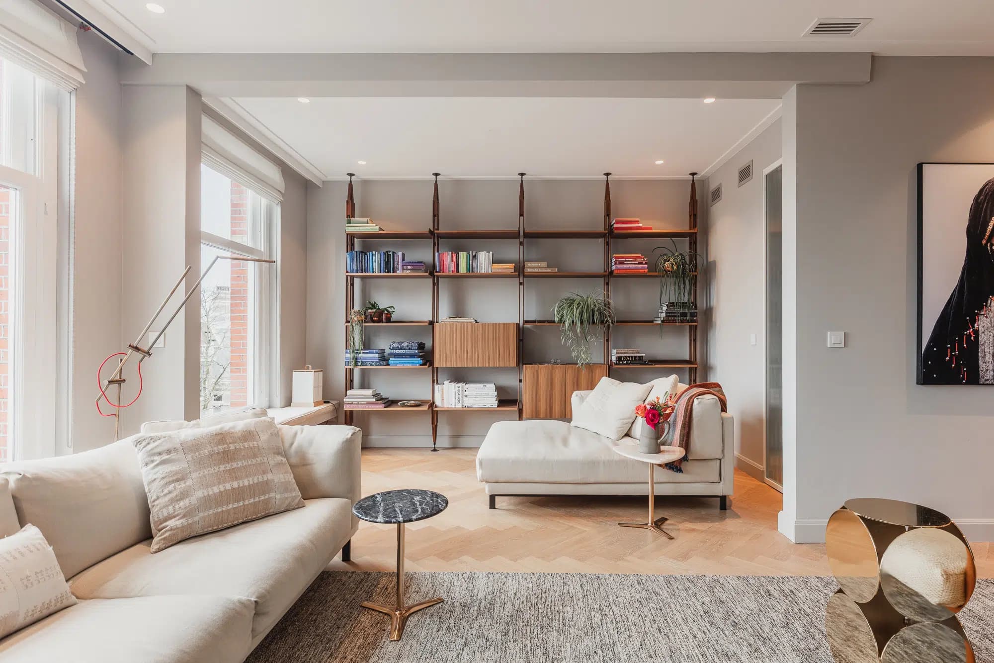 Woonkamer met zwarte open haard, beige stoelen en minimalistisch design