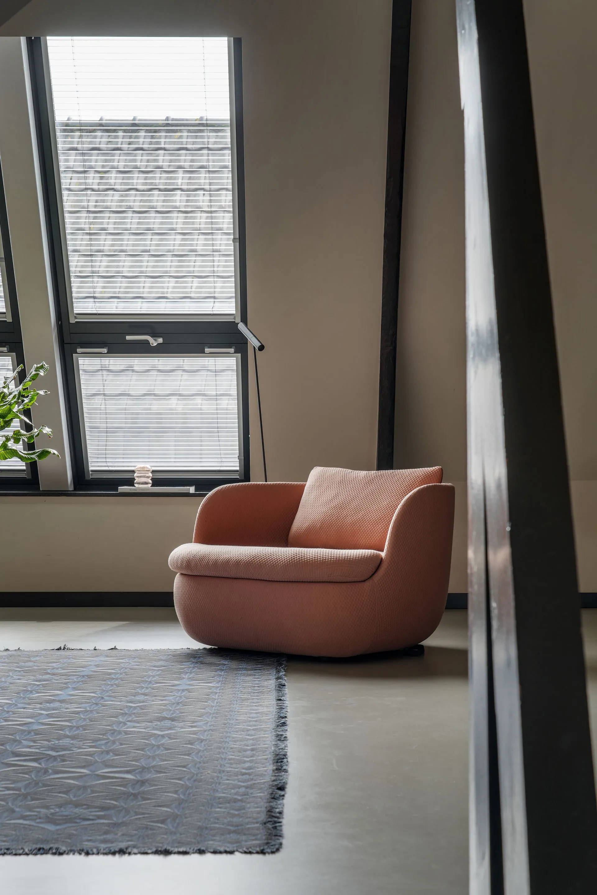 Zitruimte met terracotta muur, roze sofa en blauwe designlamp