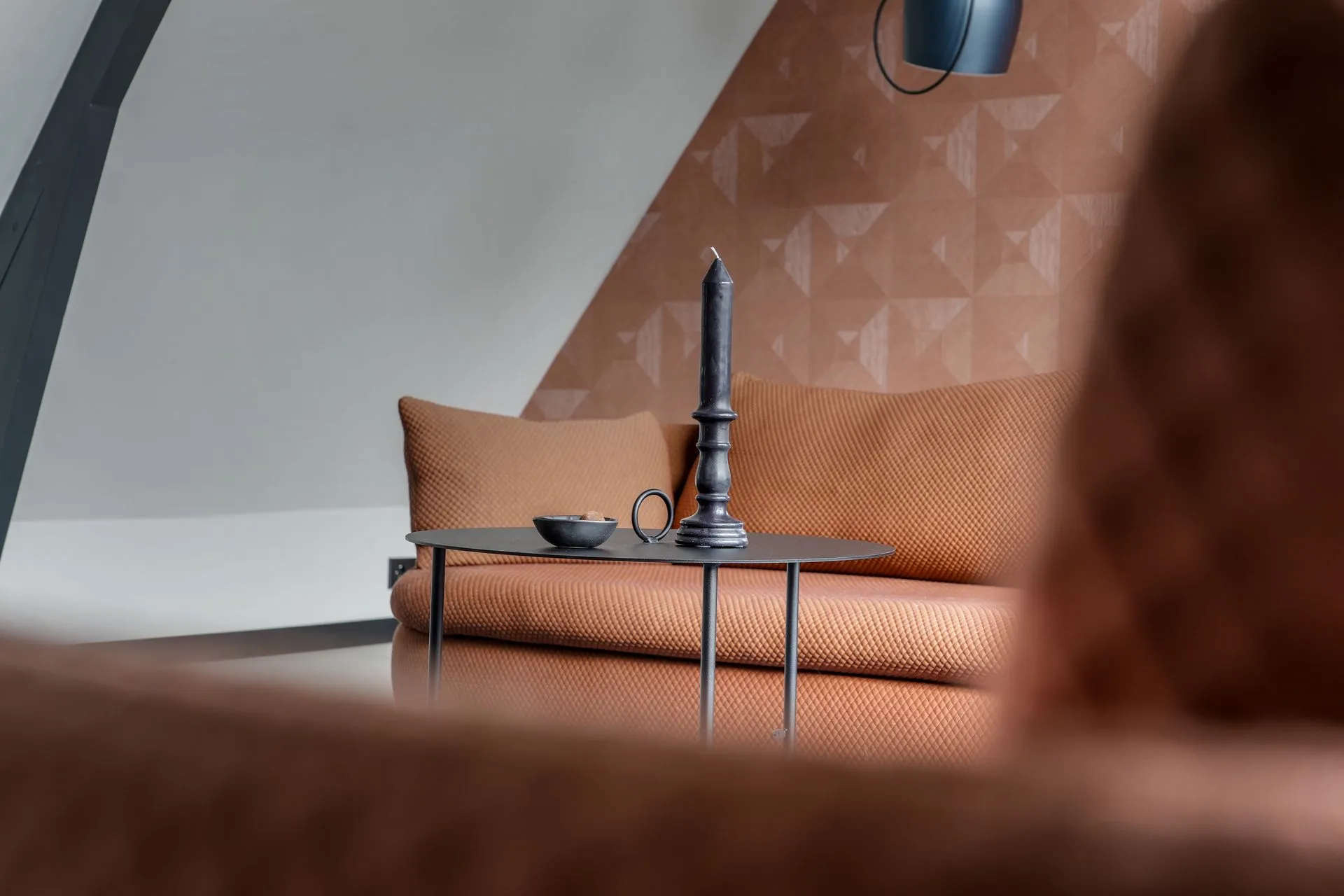 Zitbank met roze stof tegen terracotta geometrisch behang