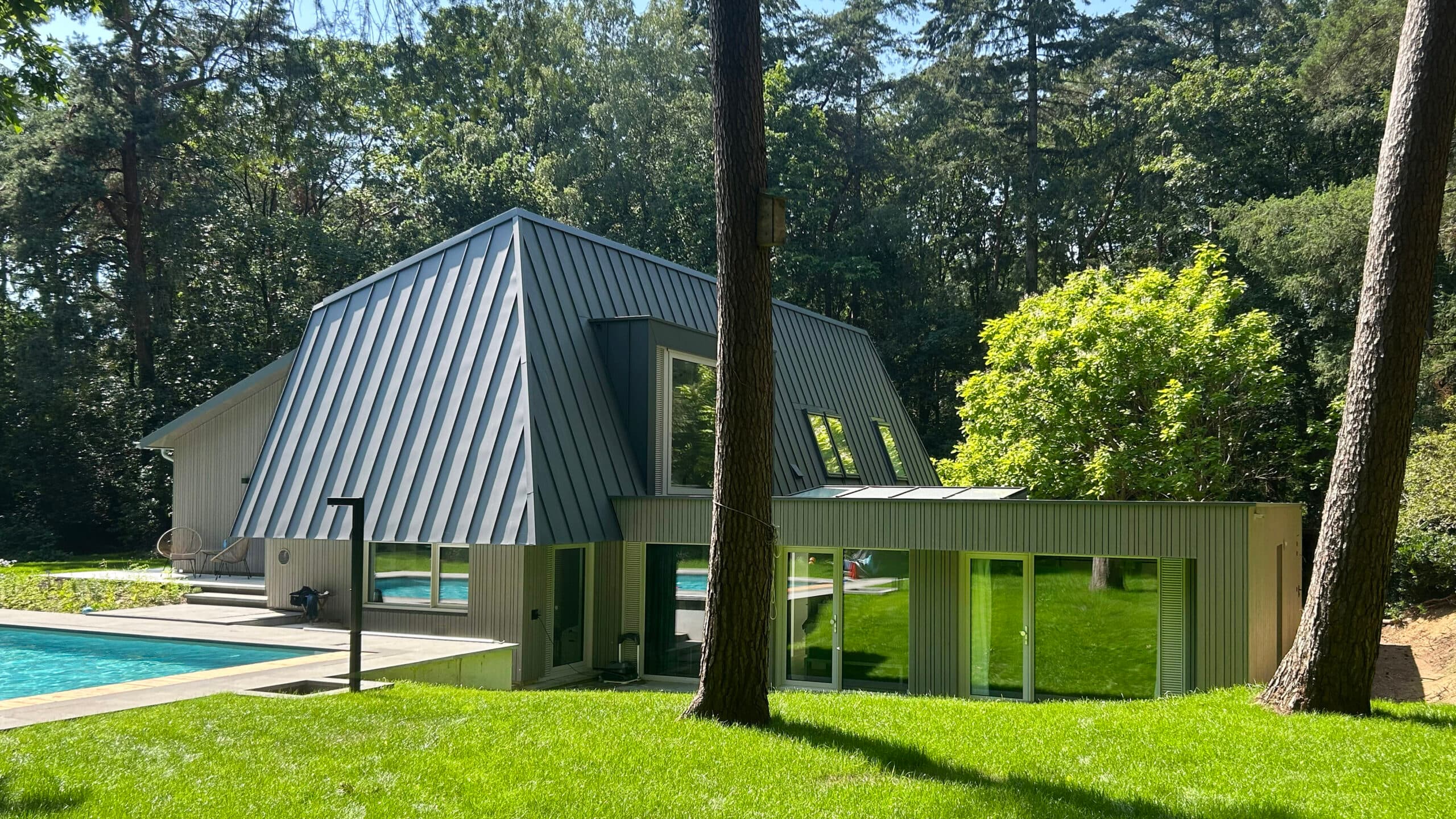 Exterieur groene villa met golfplaten dak, glazen gevel