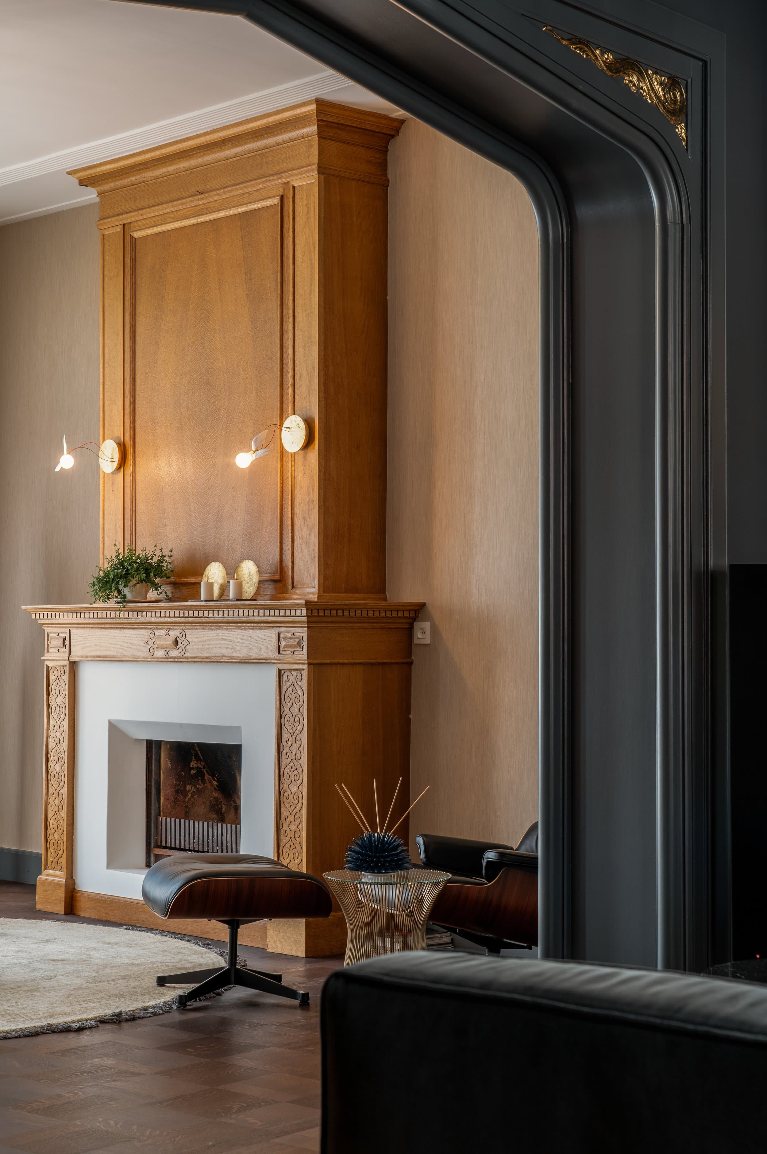 Woonkamer met houten kastvand decoratieve motieven en zwarte fauteuil