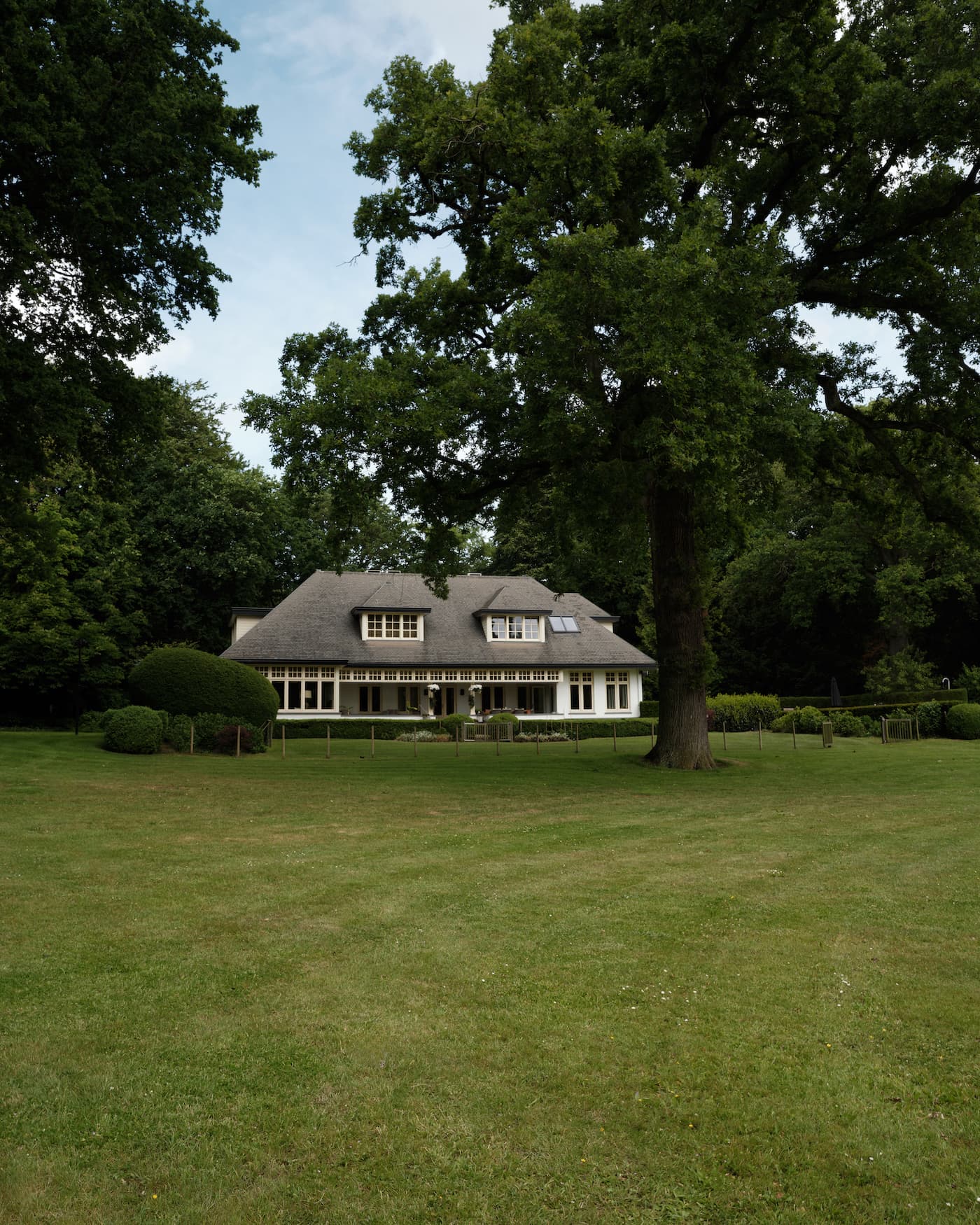 Landhuis exterieur met rieten dak en witte houten kozijnen