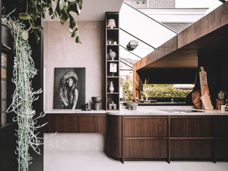 Moderne open keuken met donker hout, witte werkbladen en houten dakstructuur