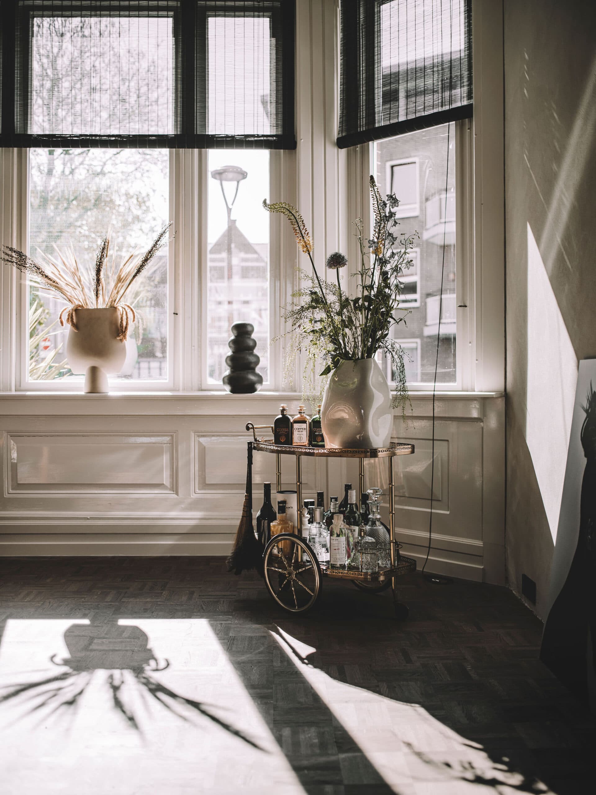 Woonkamer met houten sideboard, portretten en gepleisterde muur