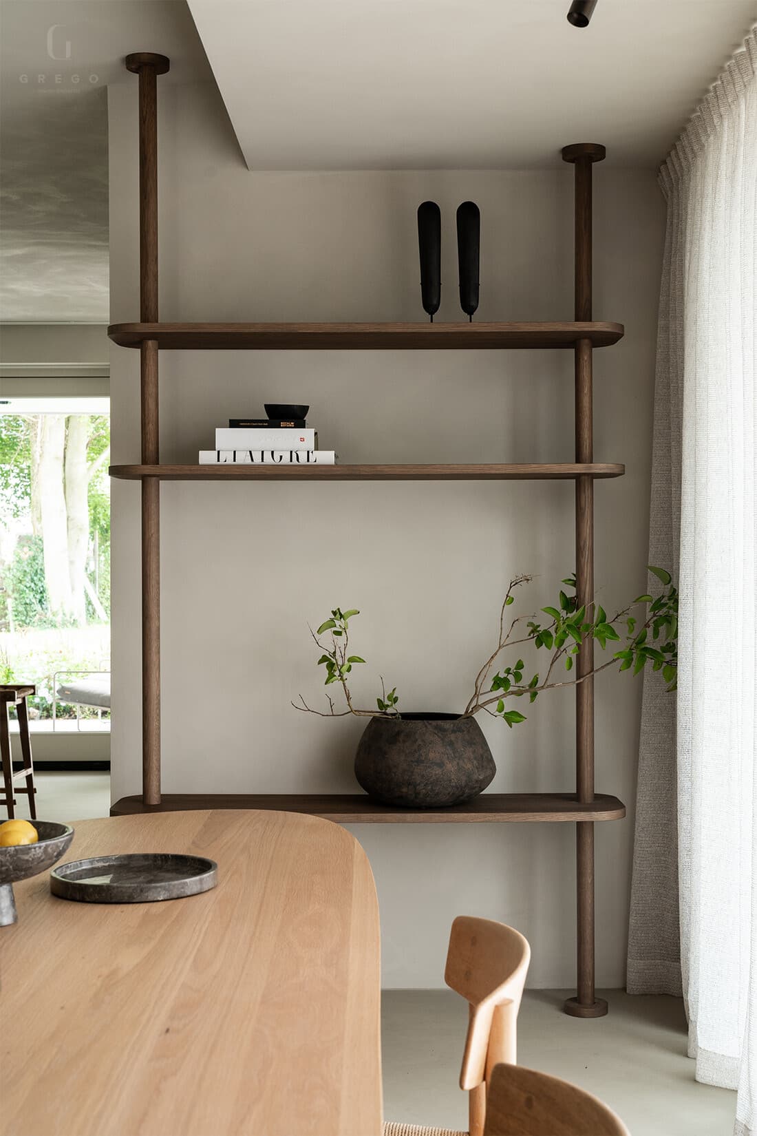 Openplan keuken en woonkamer met stellingkast en ronde hoeken