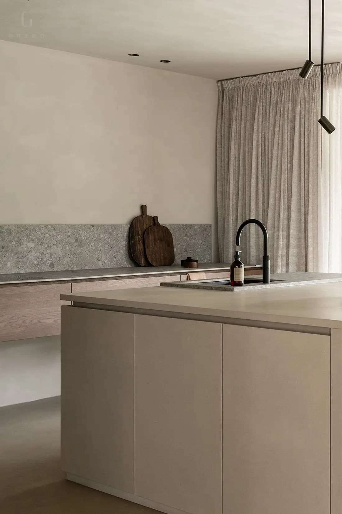 Keuken met beige eiland, grijs terrazzo backsplash en linnen gordijnen