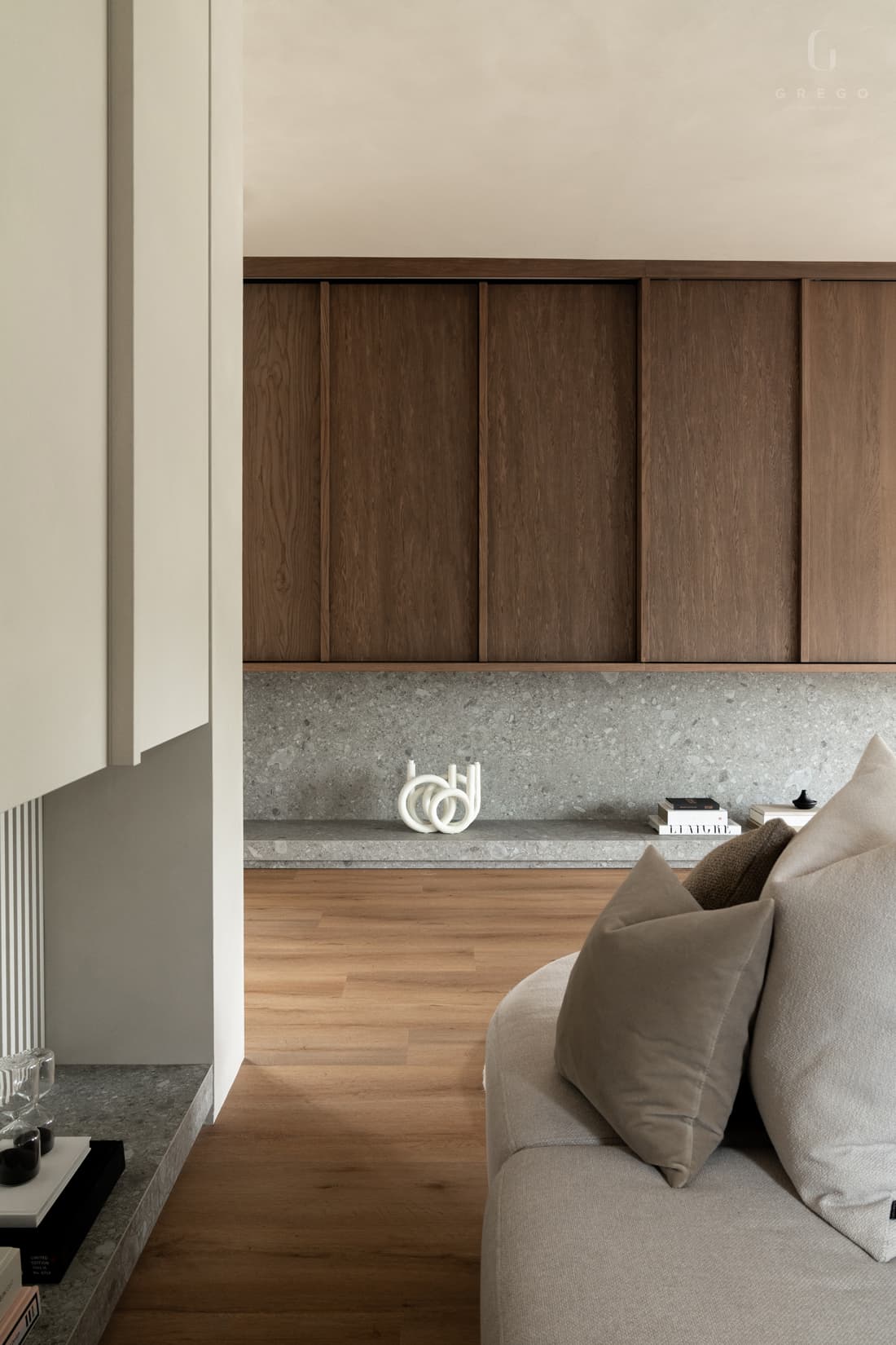Slaapkamer met beige kastenwand en zicht op woonkamer erachter