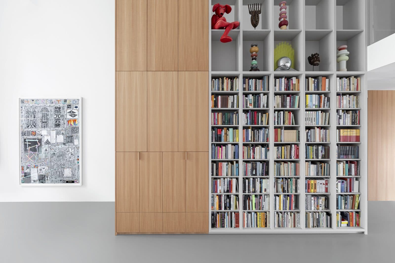 Bibliotheekwand met grijze open kasten en houten kastdeuren
