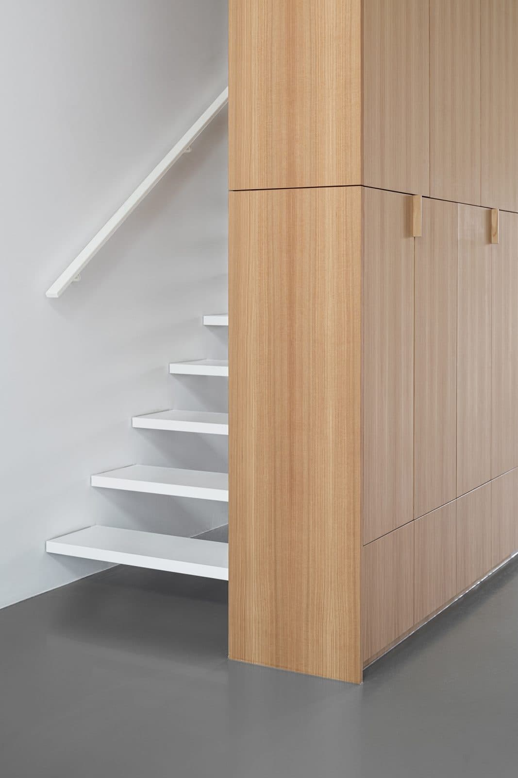 Trap naast houten kastenwand met witte treden