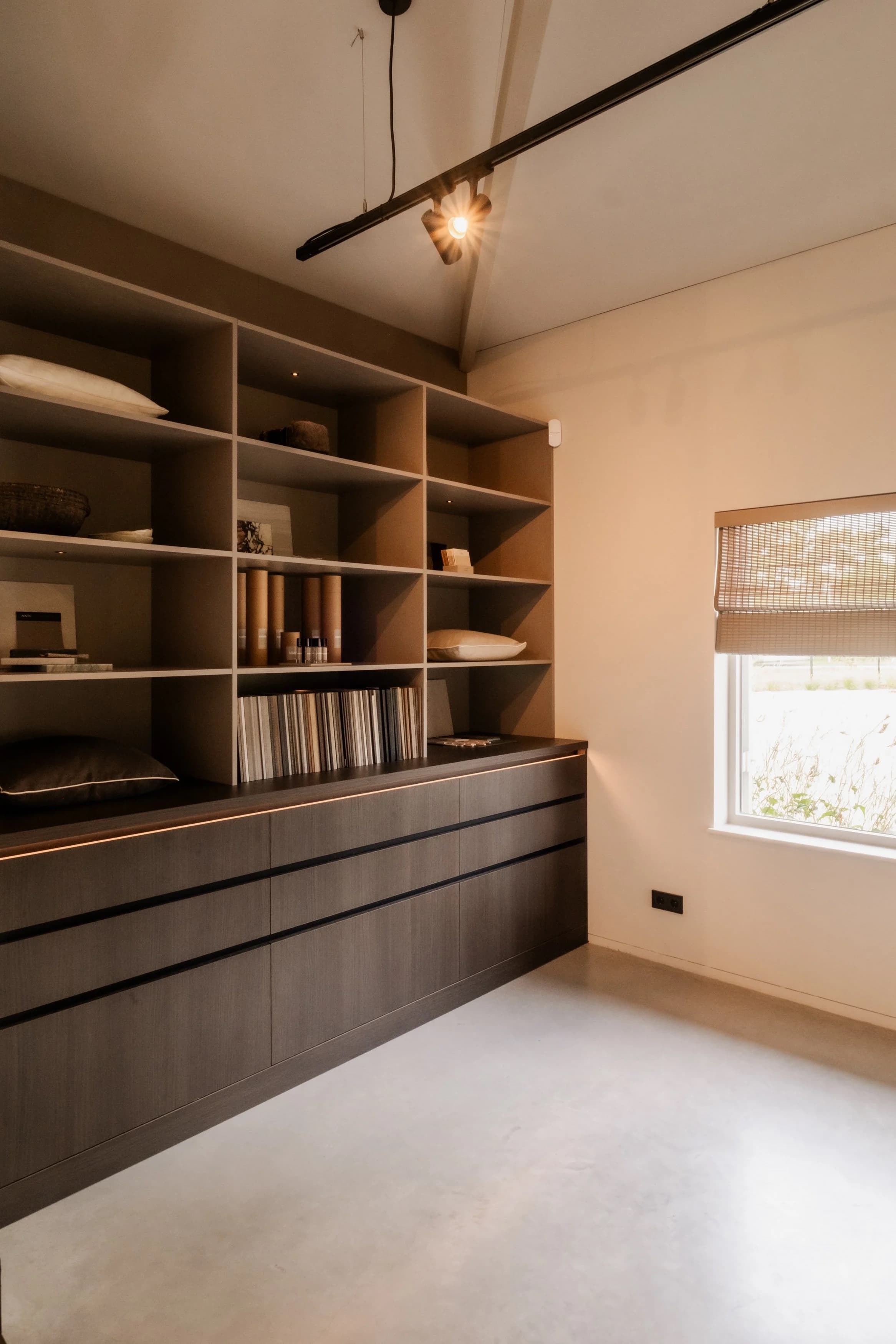 Keuken-woonkamer met zwarte kasten en beige sofa, open plan