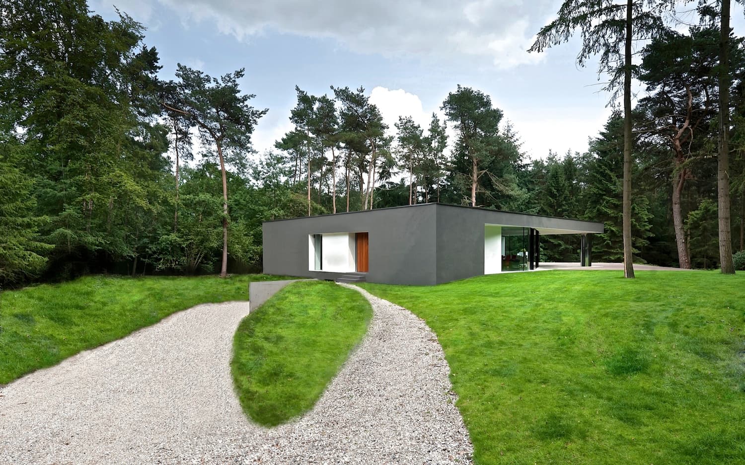 Toegangspad met grindbaan en grasveld naar moderne grijze villa