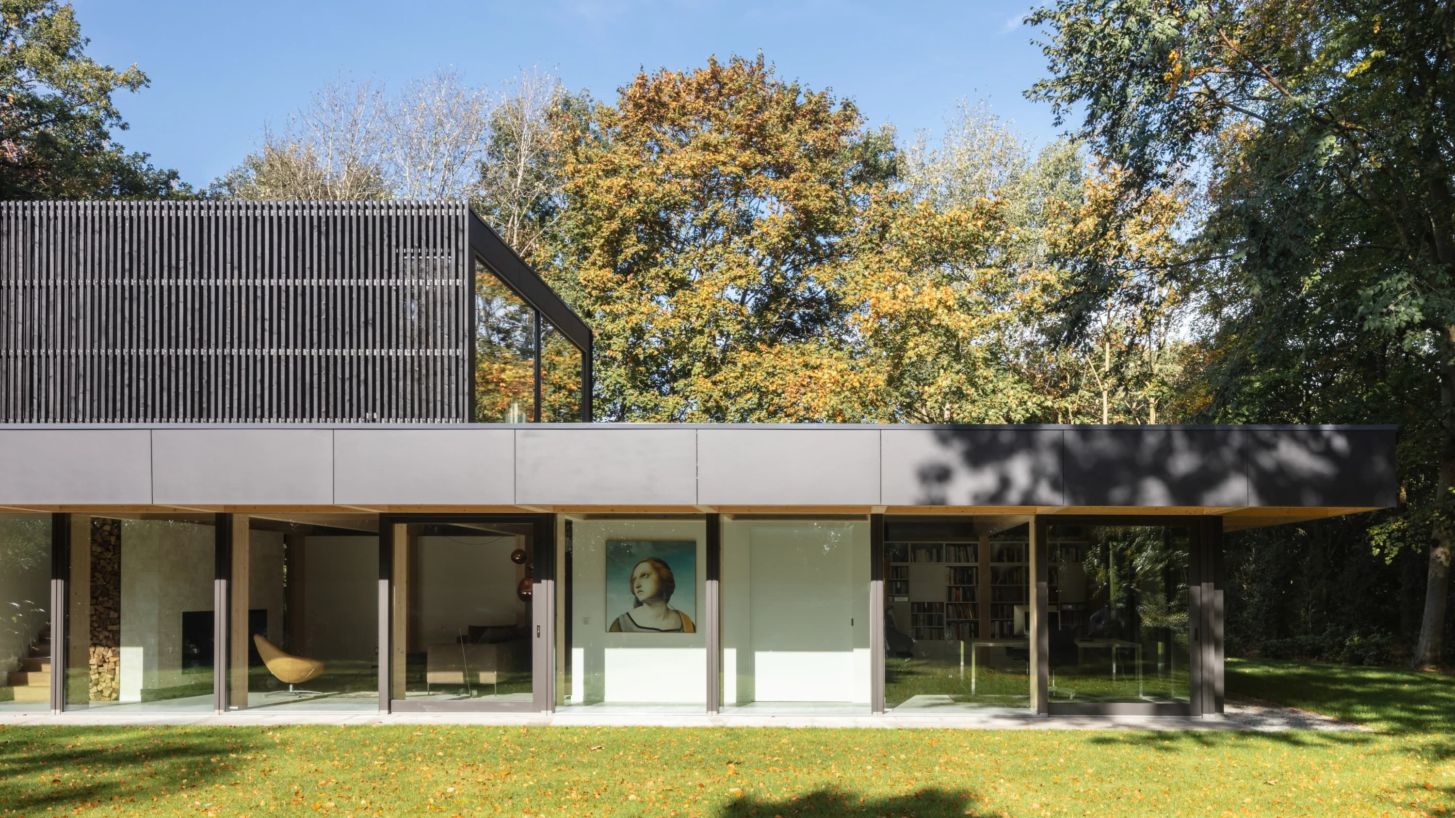 Zijkant villa met golfplaten bovenbouw en gesloten gevel, bomen op achtergrond