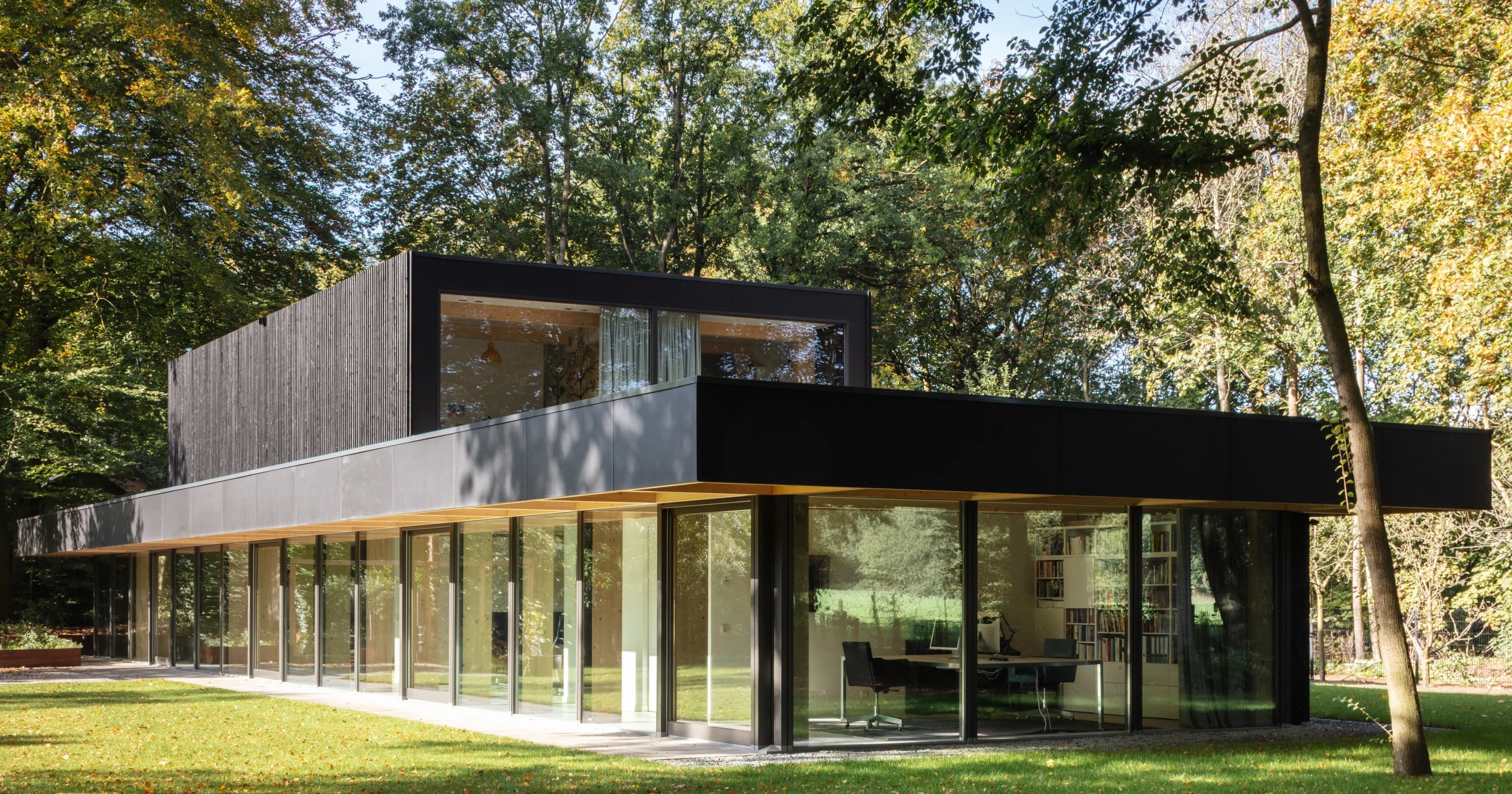 Detailzicht houten dragende kolommen en glazen gevel villa