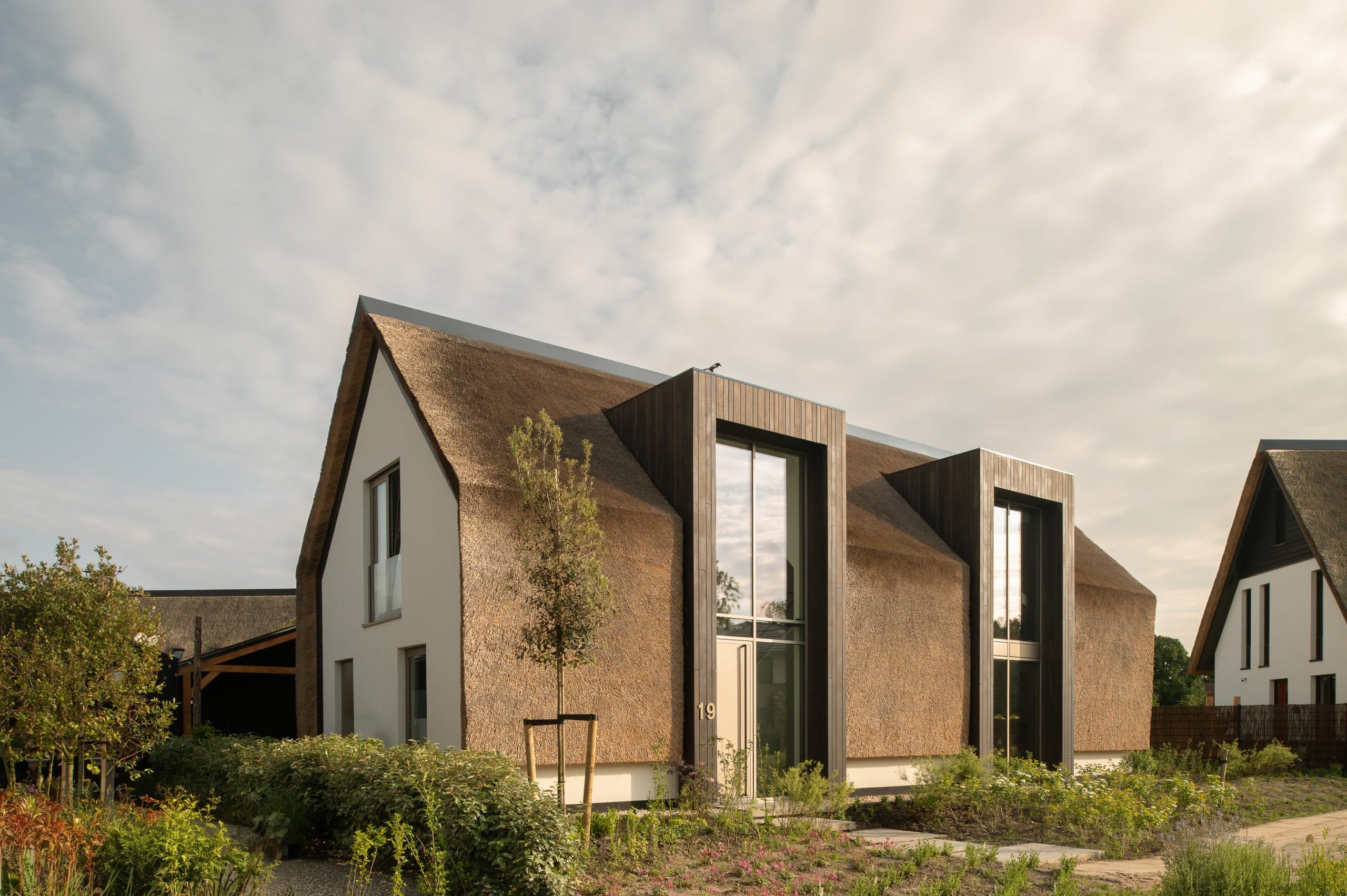 Rietgedekt woonhuis met brede panoramische glazing en groene weide