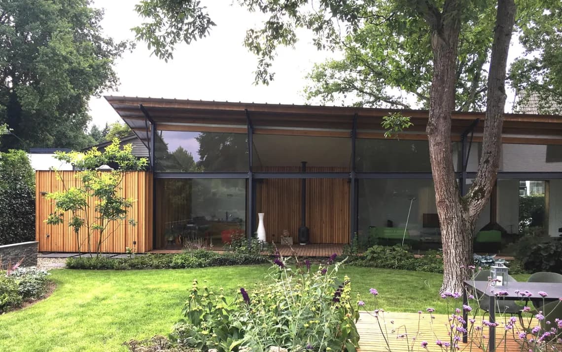 Moderne woonuitbreiding met houten gevelbekleding en grote glazen deuren