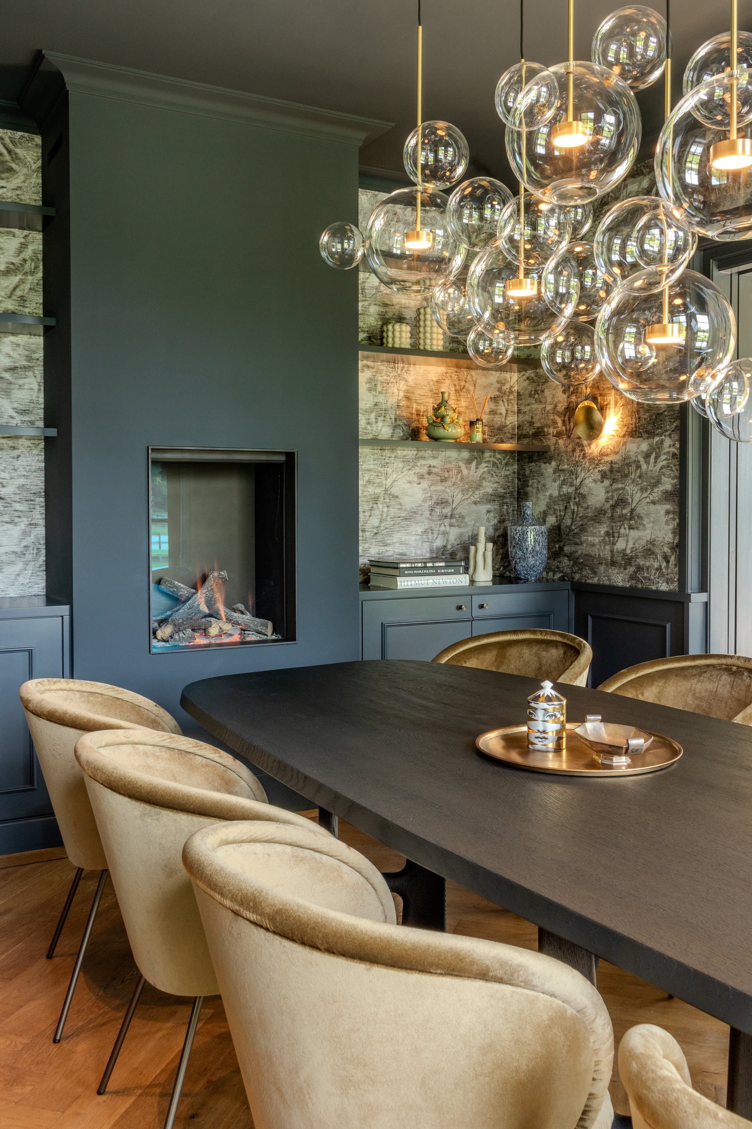 Dining room with dark table, beige chairs and cluster of glass pendant lights
