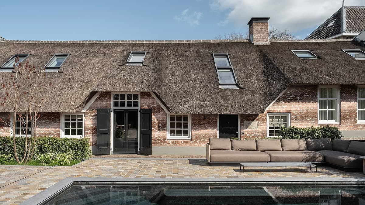 Woonkamer met houten wandkasten, open haardmeubel en zwarte hangerlamp