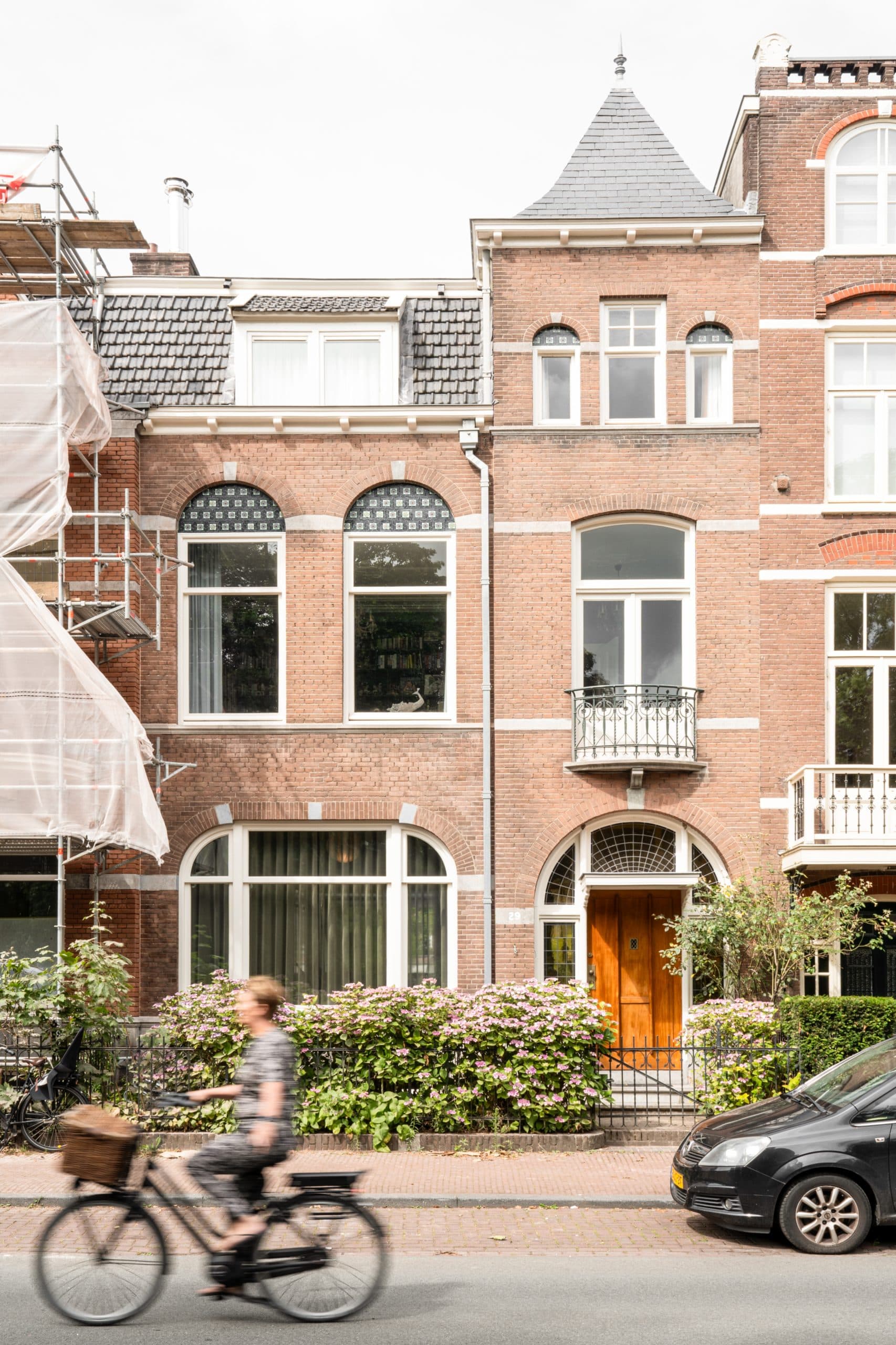 Voordeur met gemetselde boogopening, houten deur en hortensia's