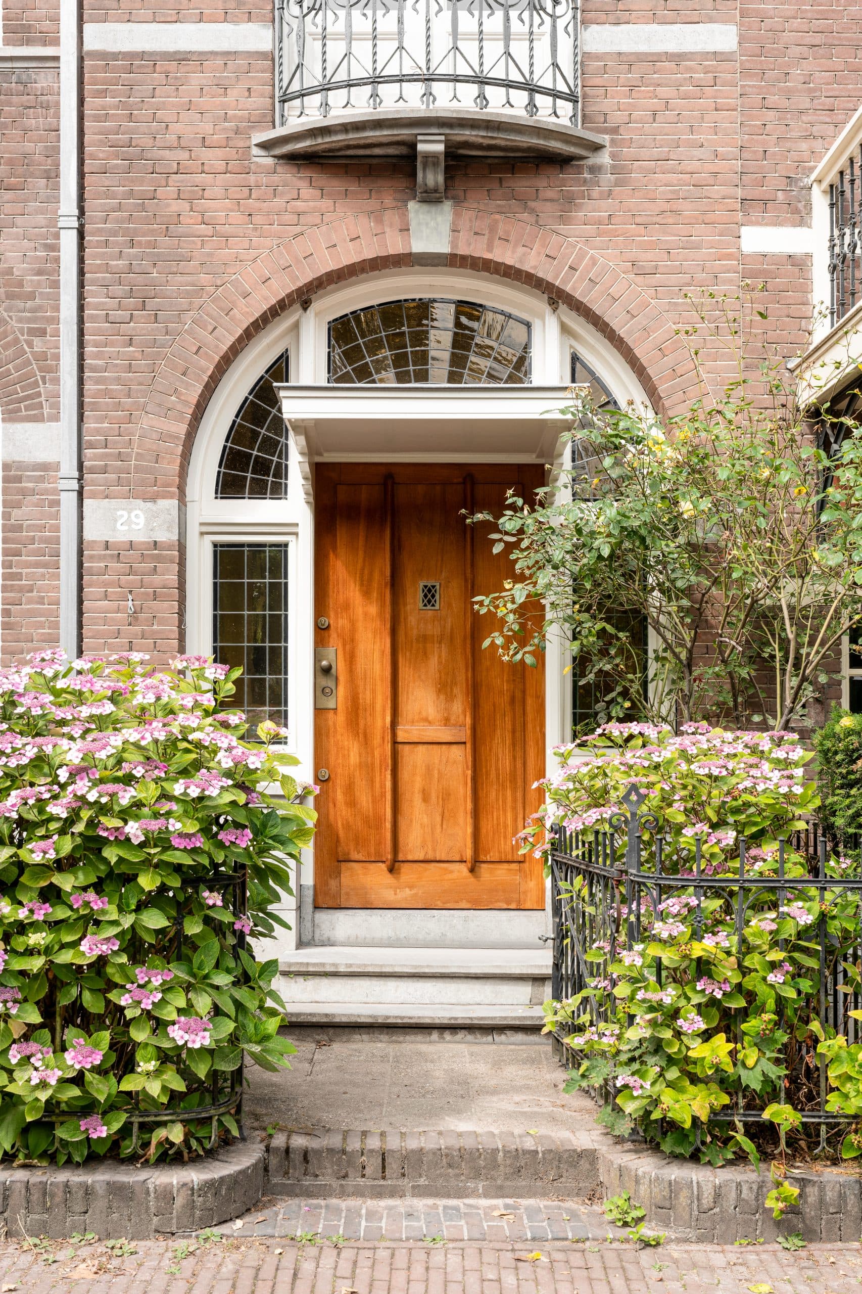 Tuinzijde woning met moderne grijze uitbouw en groene beplanting