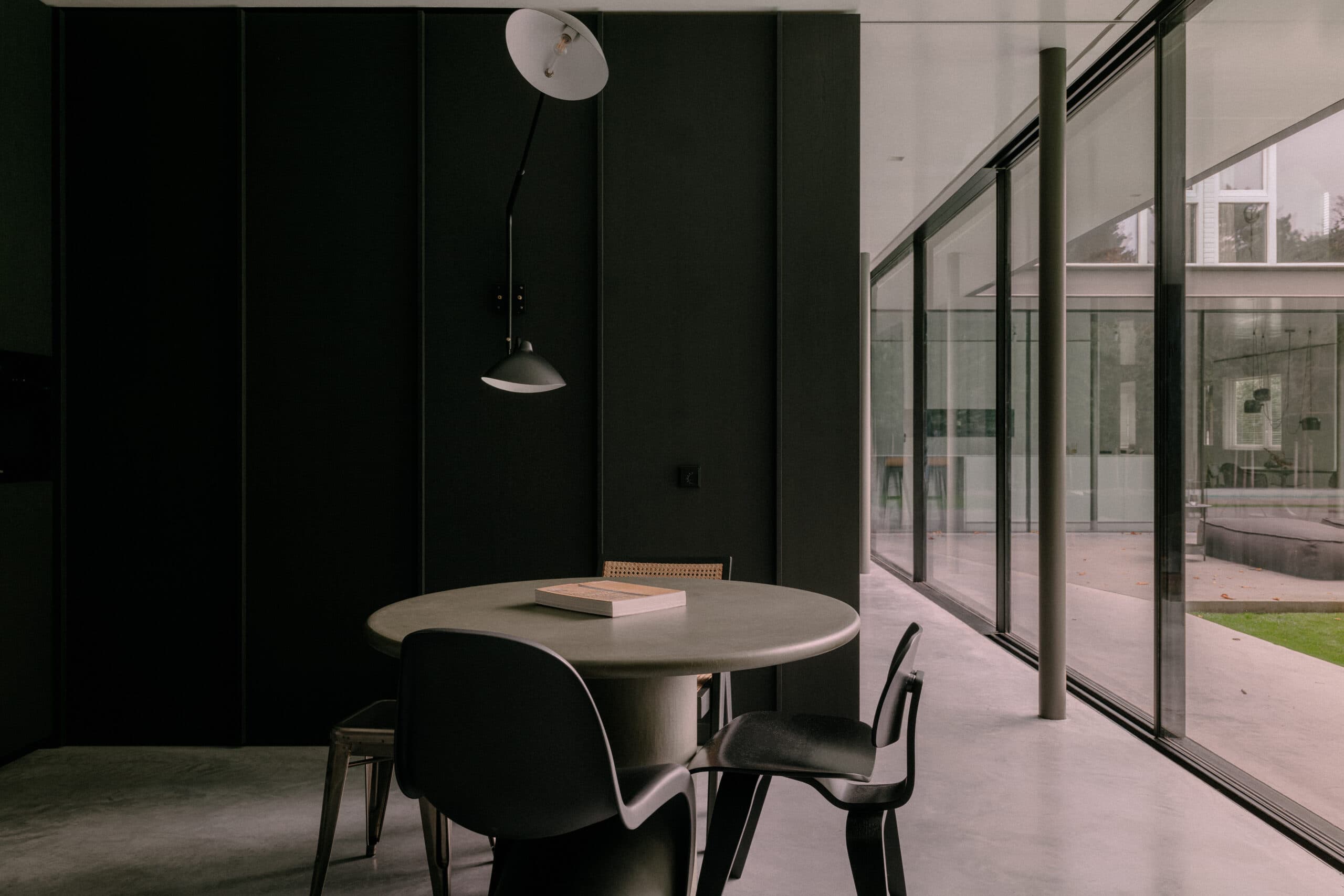 Eettafel met donkergroene wandbekleding en glazen schuifdeuren