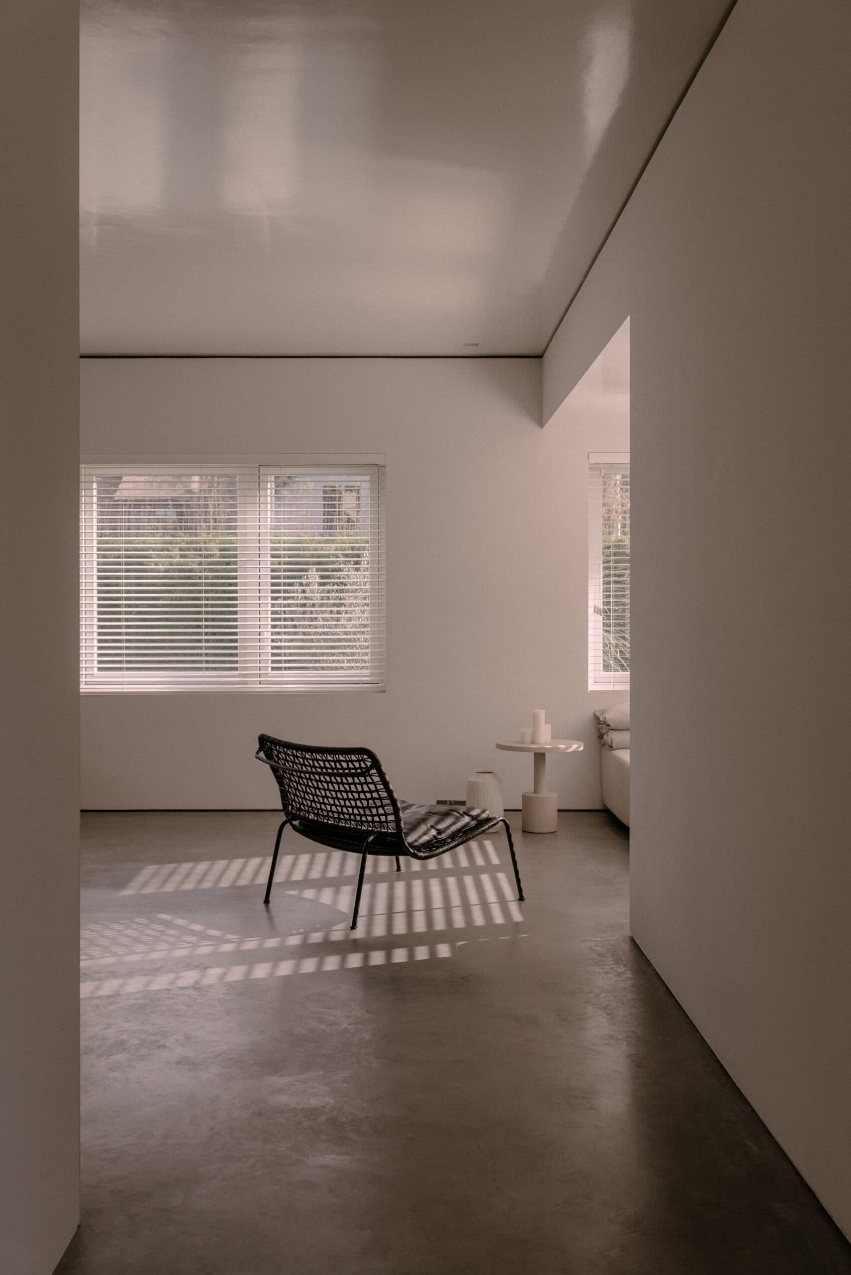 Minimalistisch interieur met betonnen vloer en raamluiken
