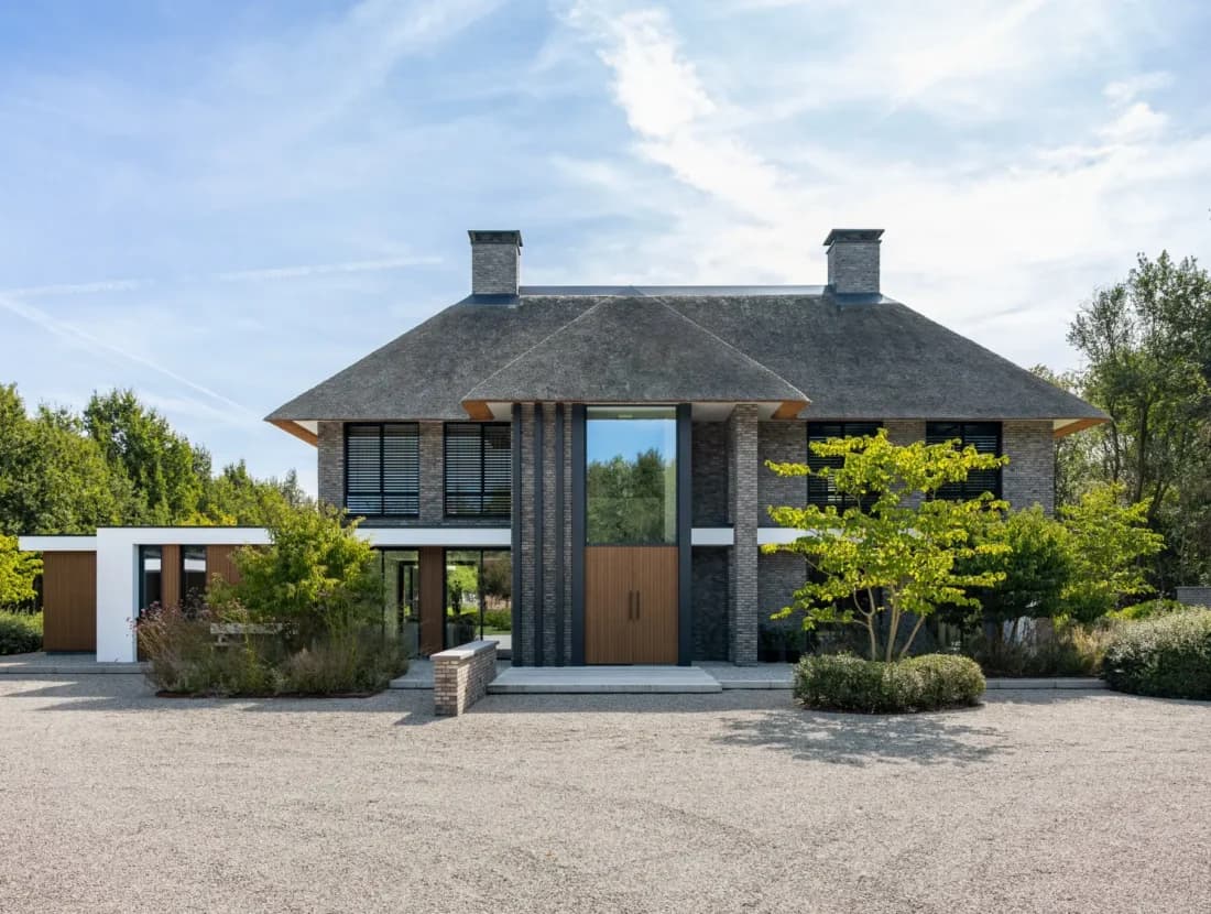 Moderne bakstenen villa met schildakdak en grindoppervlak