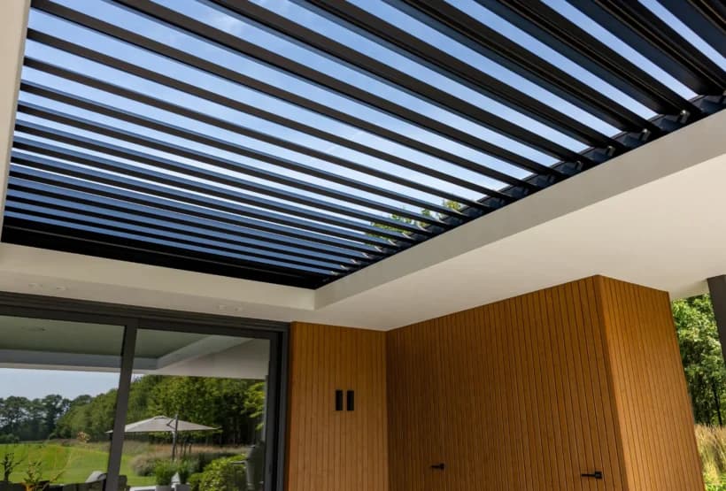 Moderne terrasoverkapping met zwarte latten en witte betonnen onderkant