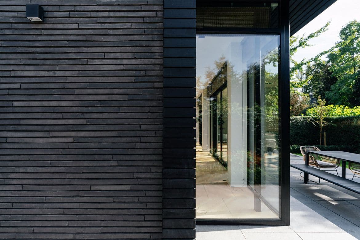 Zwarte houten schuurwand met groot glazen schuifdeursysteem