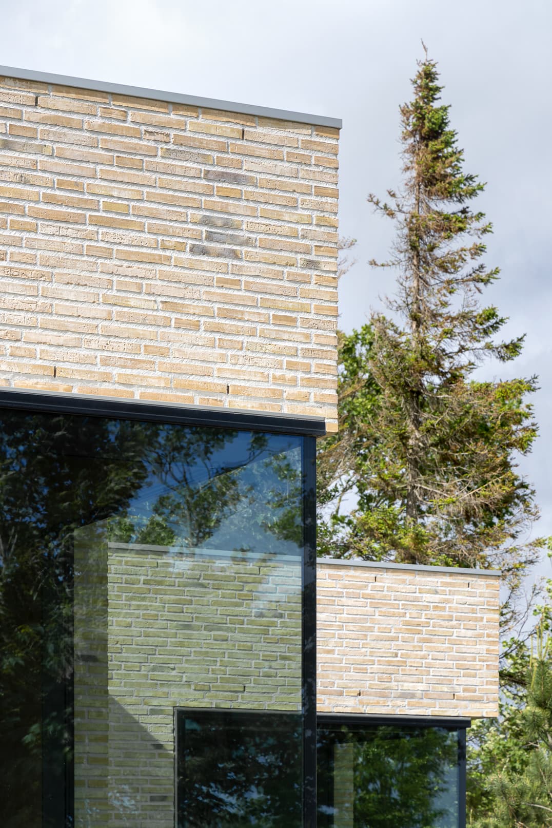 Moderne bakstenen woning met grote raamopening en grindoprit