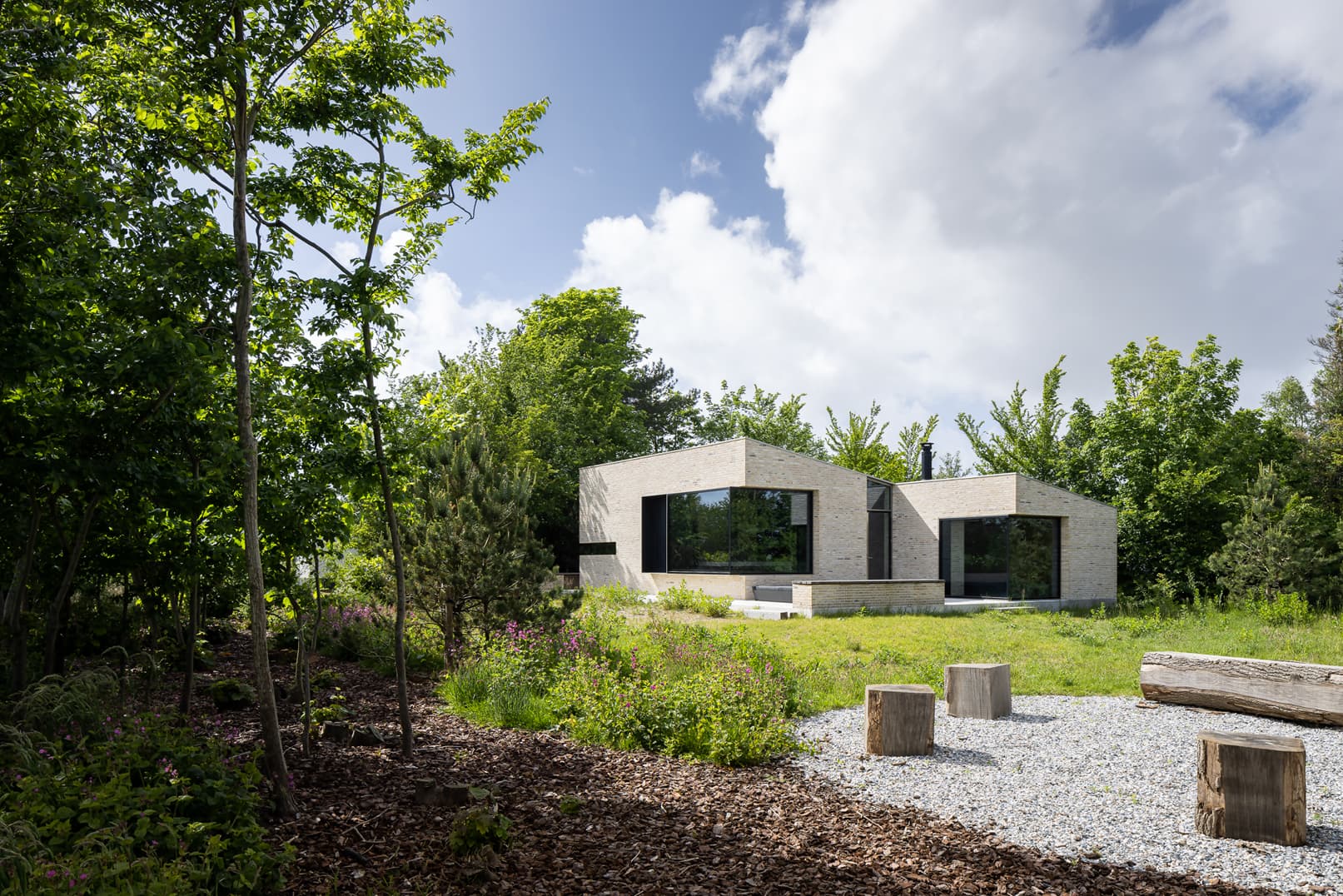 Moderne betonnen villa met grote raampartijen omgeven door bomen