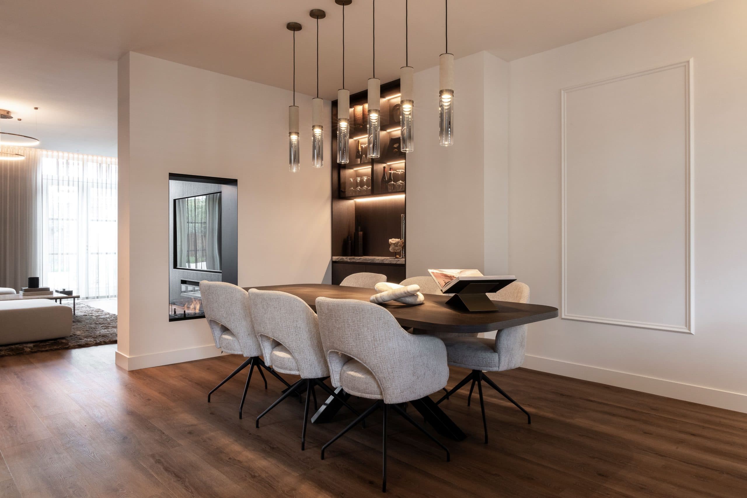 Minimalistische eetkamer met donkere kastenwand en wandverlichting