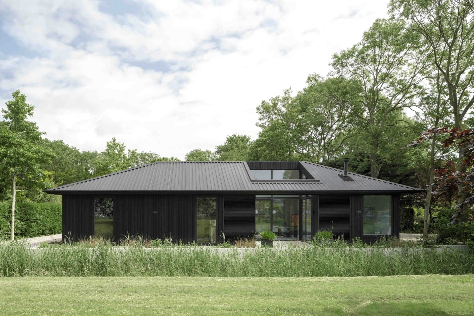Moderne bungalow met zwart golfplaten gevel en panoraamramen