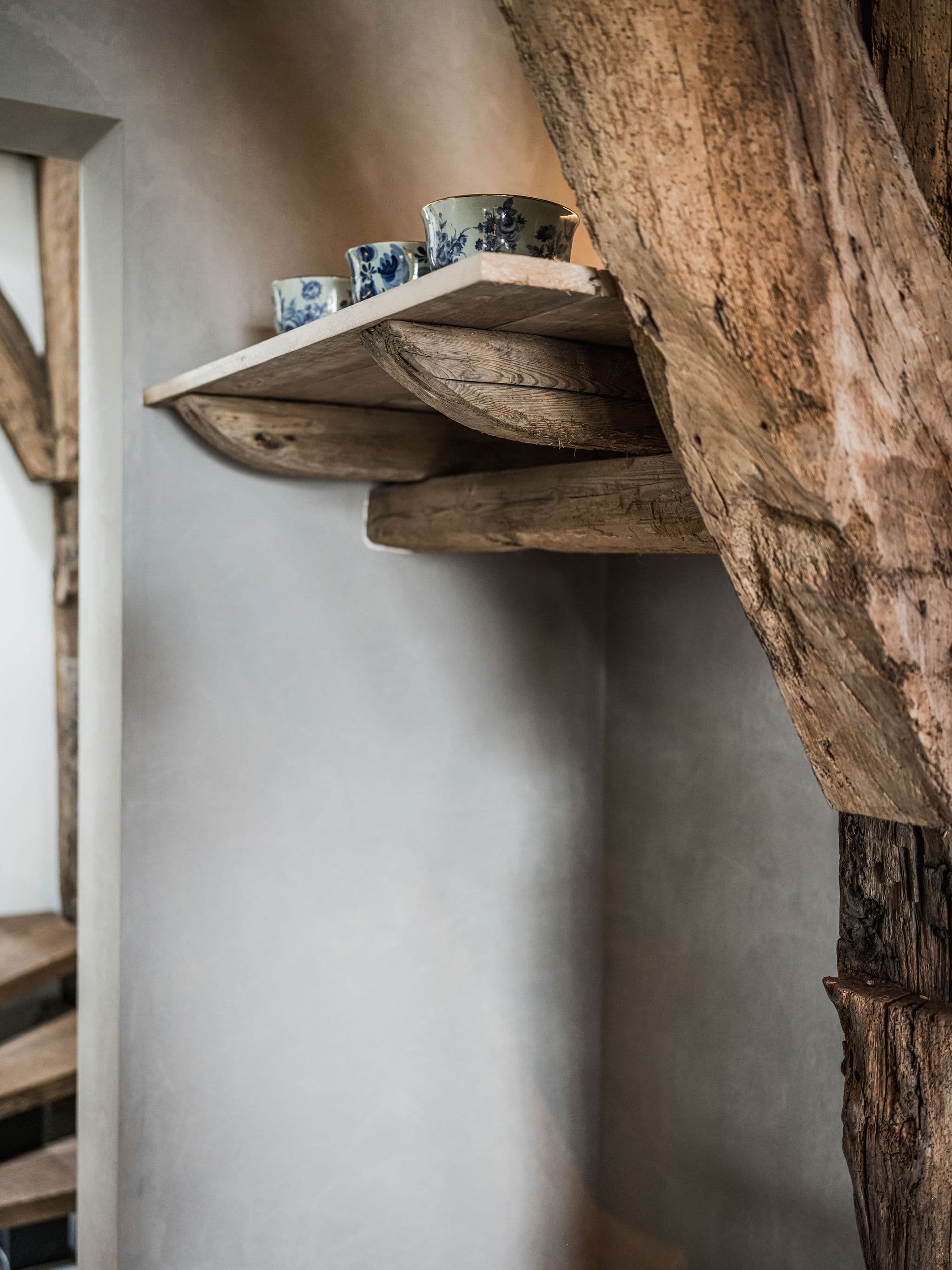 Eettafel onder stalen hanglampjes en houten balkenstructuur met foto