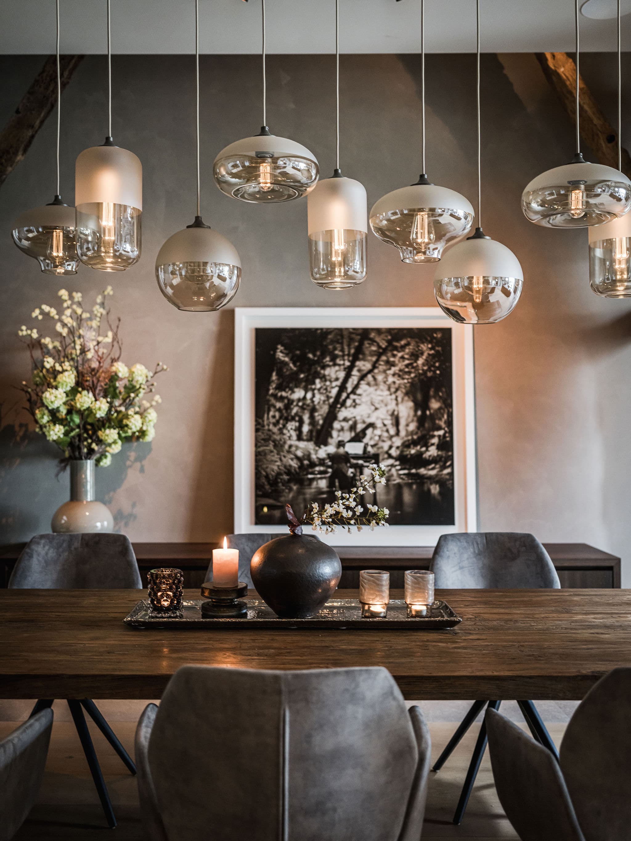 Keuken met zwart eiland, houten balken en moderne witkasten