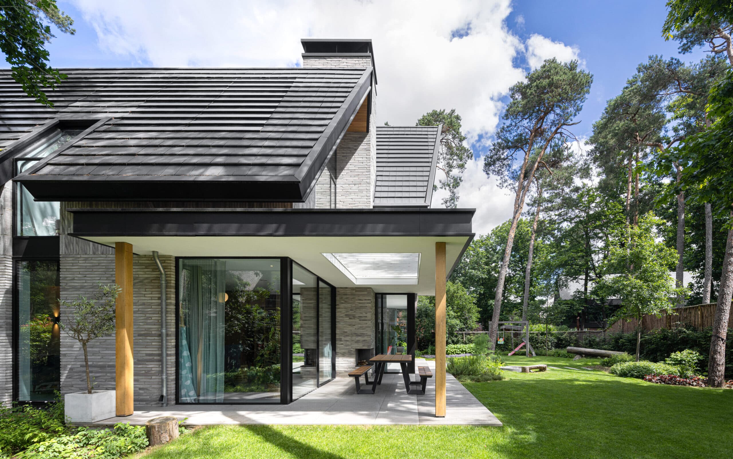 Moderne villa met leisteen dak, grijze gevels en houten terrasoverkapping