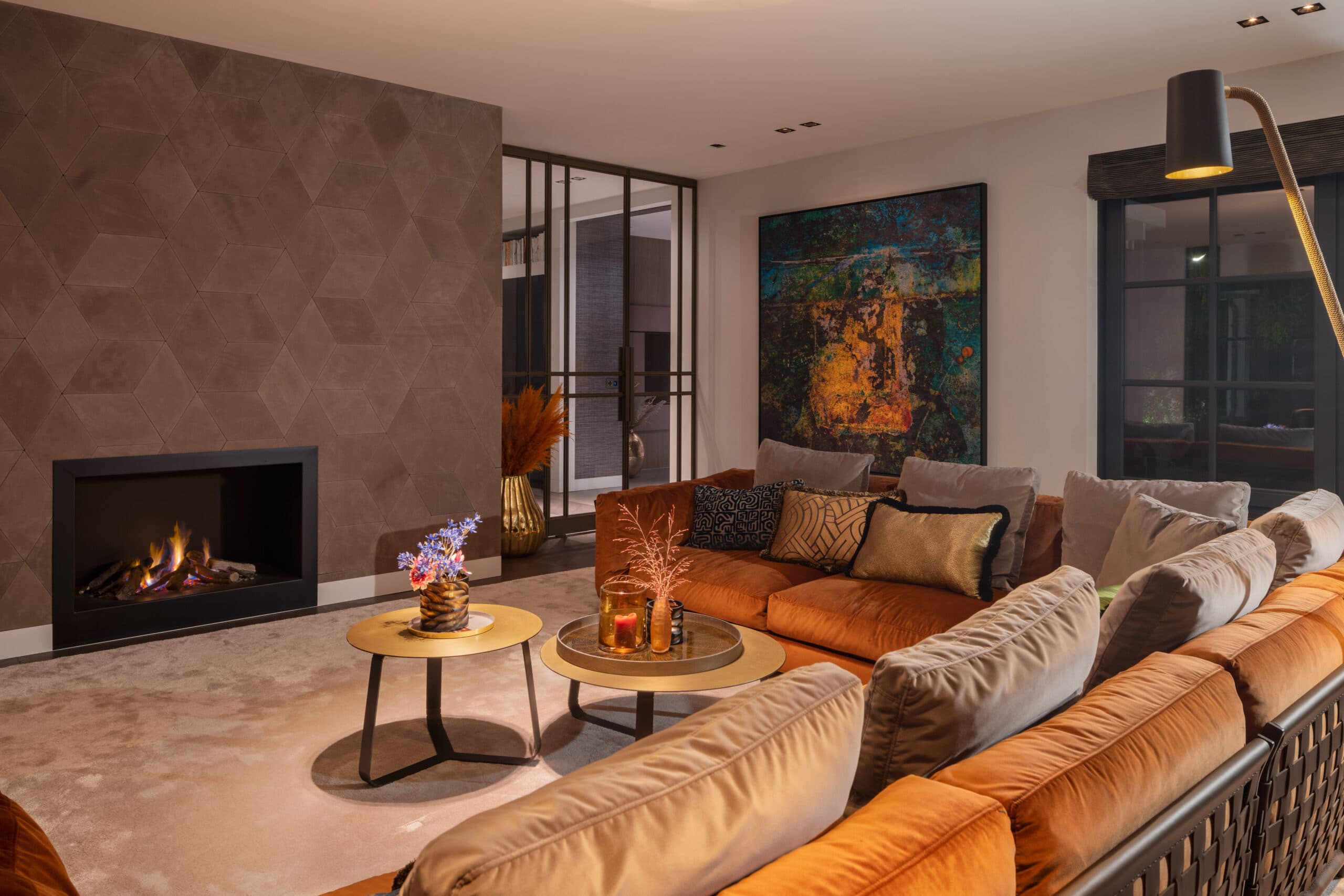 Grote woonkamer met oranje zitbank en abstract schilderij