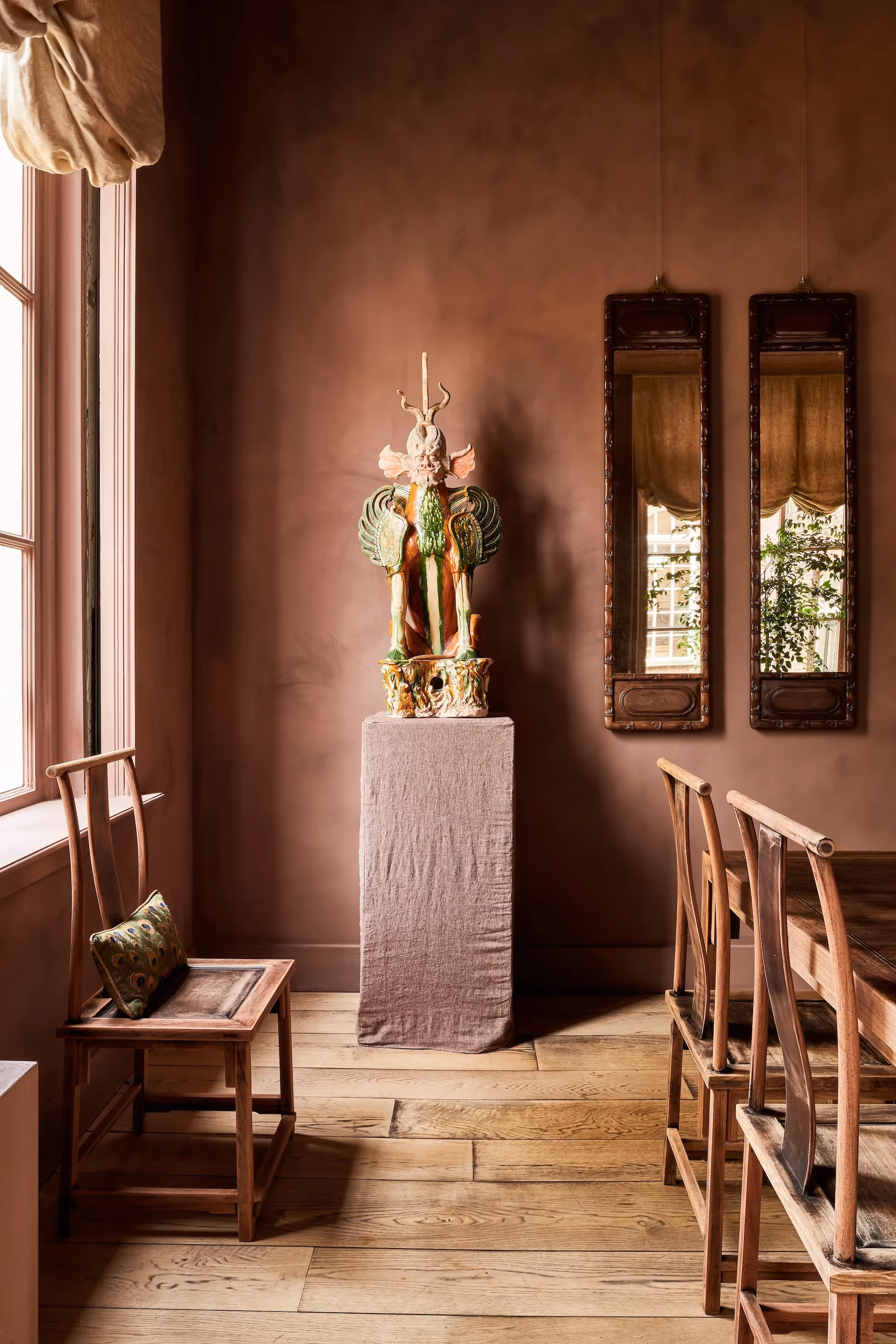 Interieurdetail met abstract kunstwerk, houten stoel en terracottawand