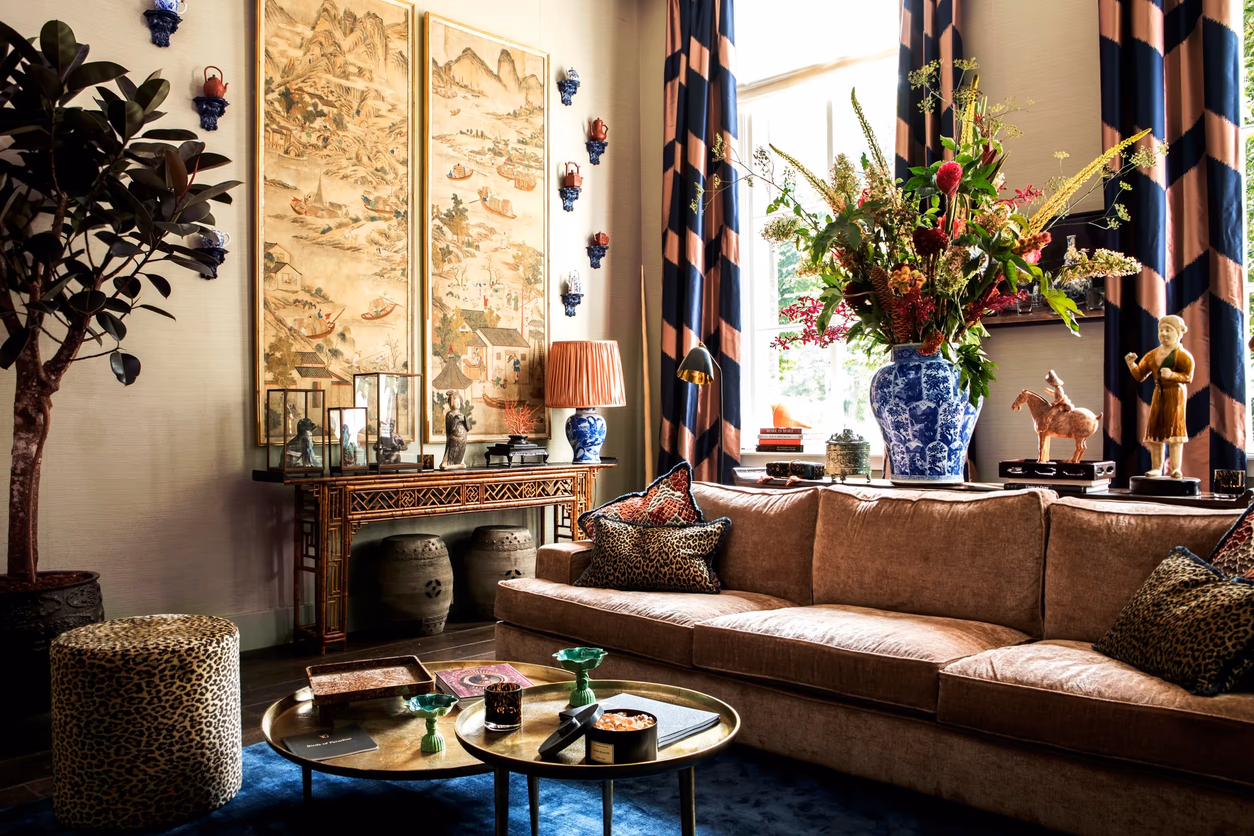 Woonkamer met bruinleren bank, blauw-wit porselein en Chinese schilderijen