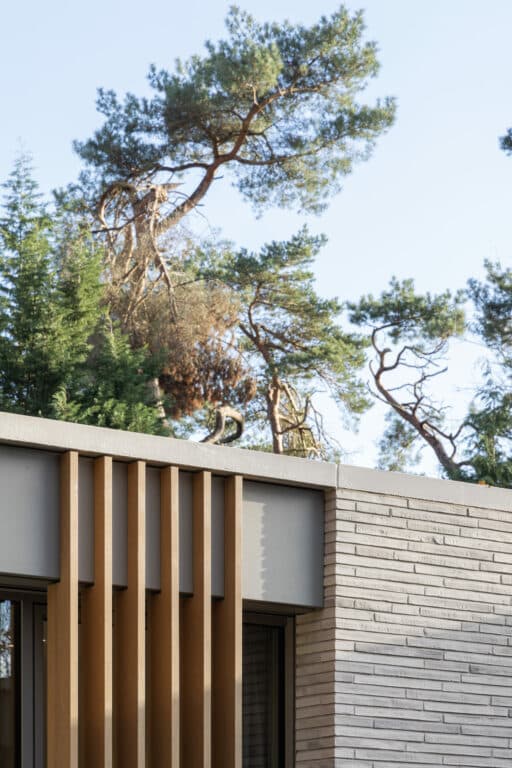 Achtertuin gevel met wit baksteenwerk en gestapelde ventilatieroostertjes