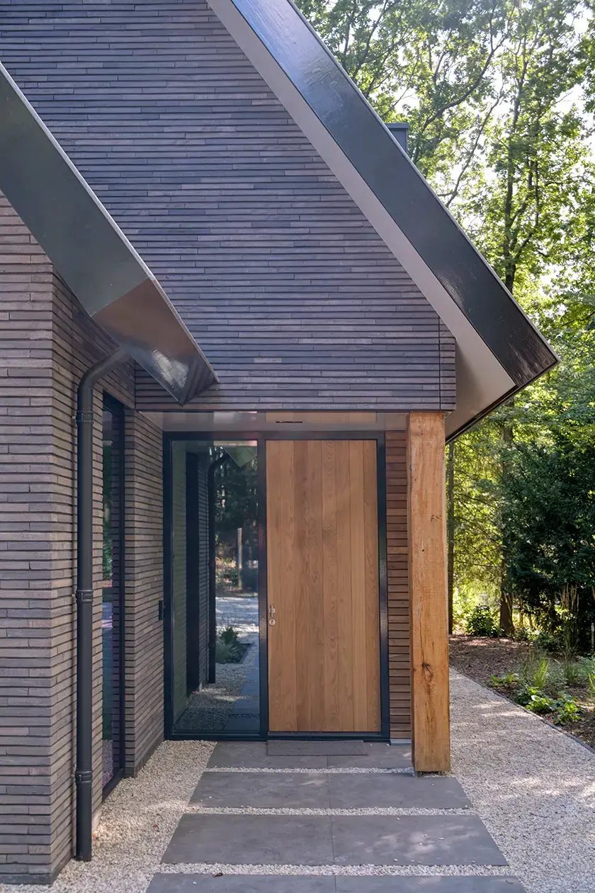 Modern entrance with black sliding doors and wooden cladding details