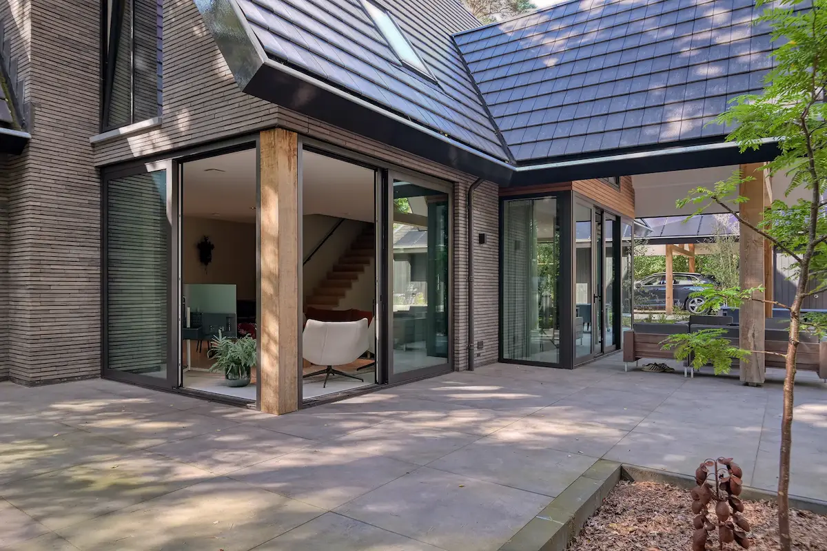 Contemporary home with brick and wood exterior, dark roof tiles