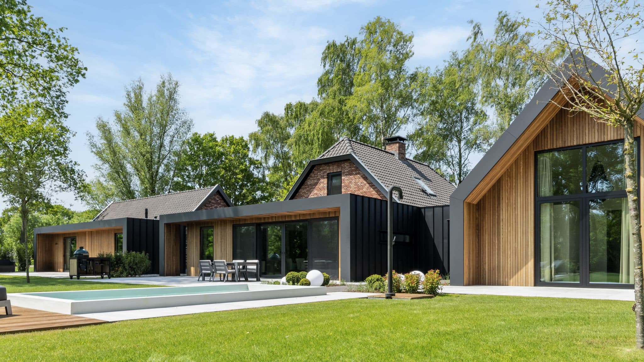 Moderne villa met zwarte metalen randen, houten bekleding en binnenterras