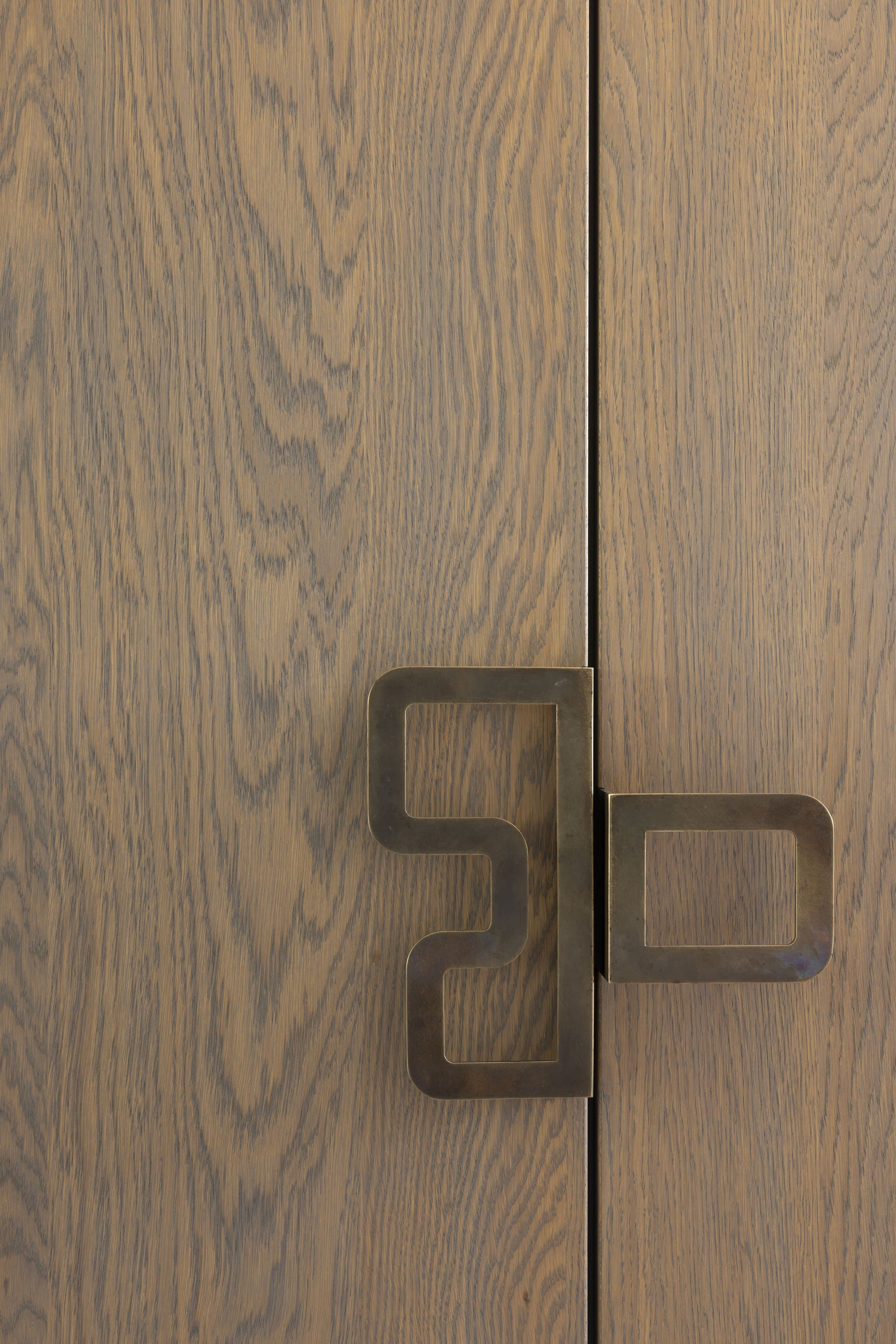 Woonkamer met houten eettafel, gouden wandobject en hangende lampen