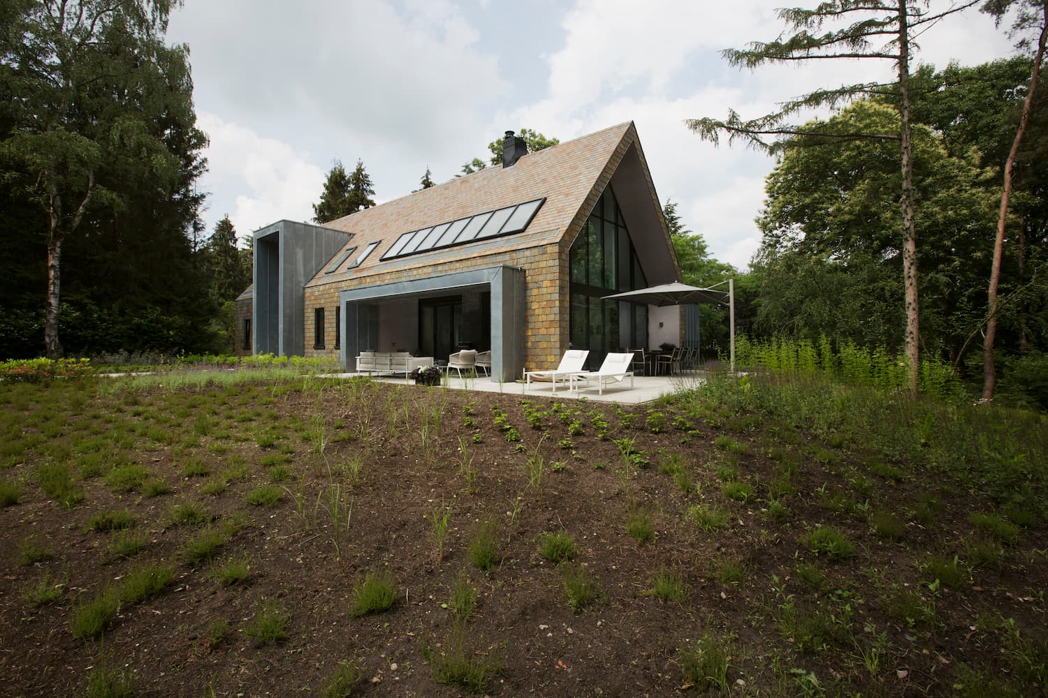 Contemporary home with stone facade and modern glass wing