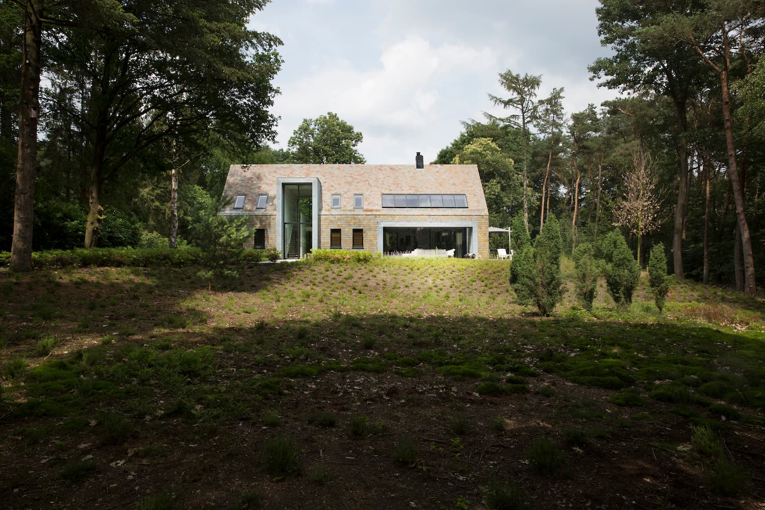 Stone house with tall white glass and steel entry tower