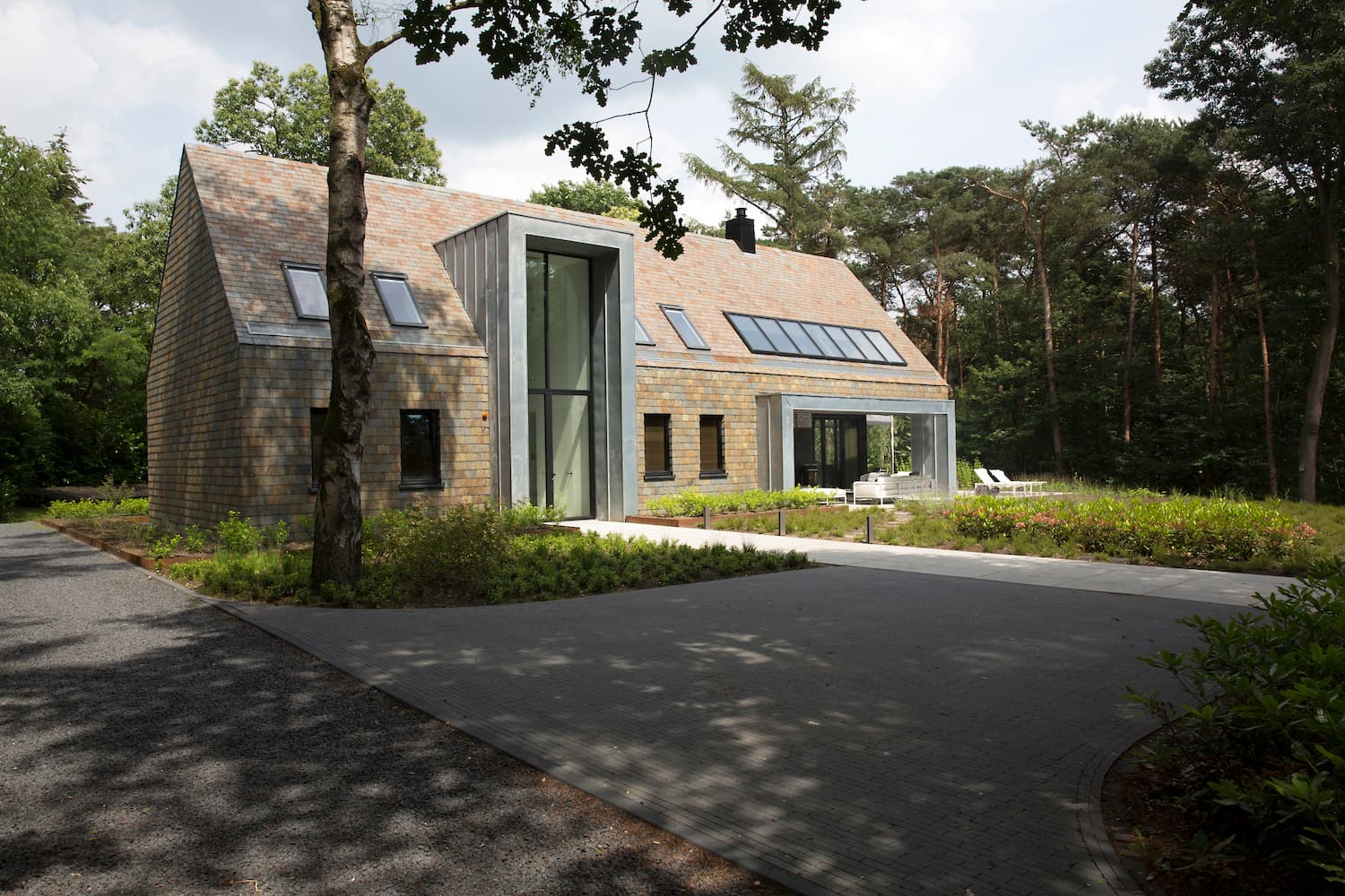 Modern house with natural stone and glass tower entrance