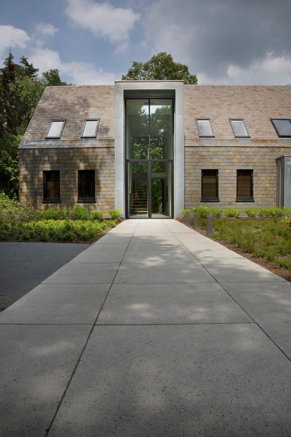 Modern sandstone building with vertical glass tower accent