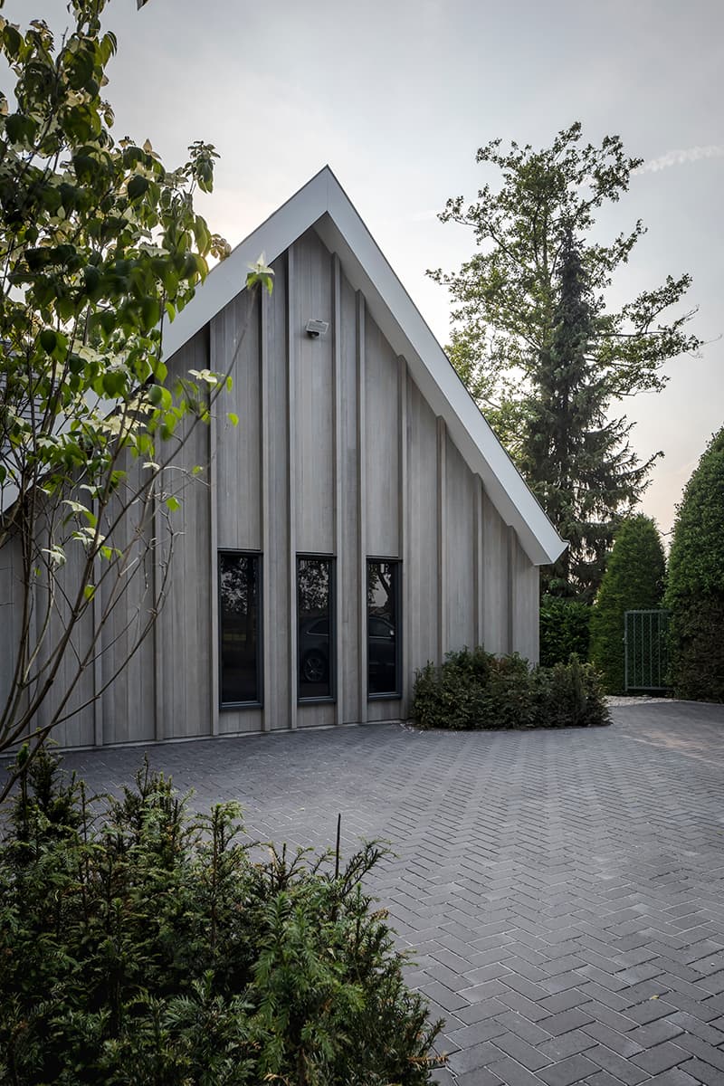 Wellnessgebouw met verticale houten latten en grote raampartijen