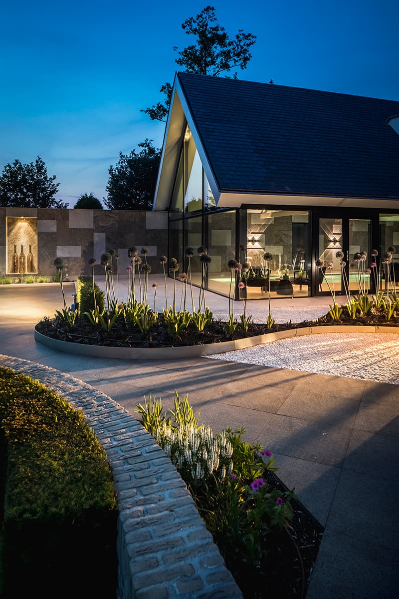Wellnessgebouw bij nacht met stenen accent en grote glazen gevels